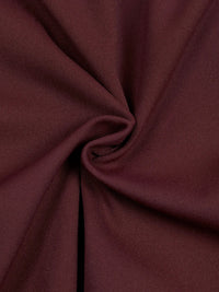 Bodysuit fabric close-up in burgundy with soft knit texture and folds.