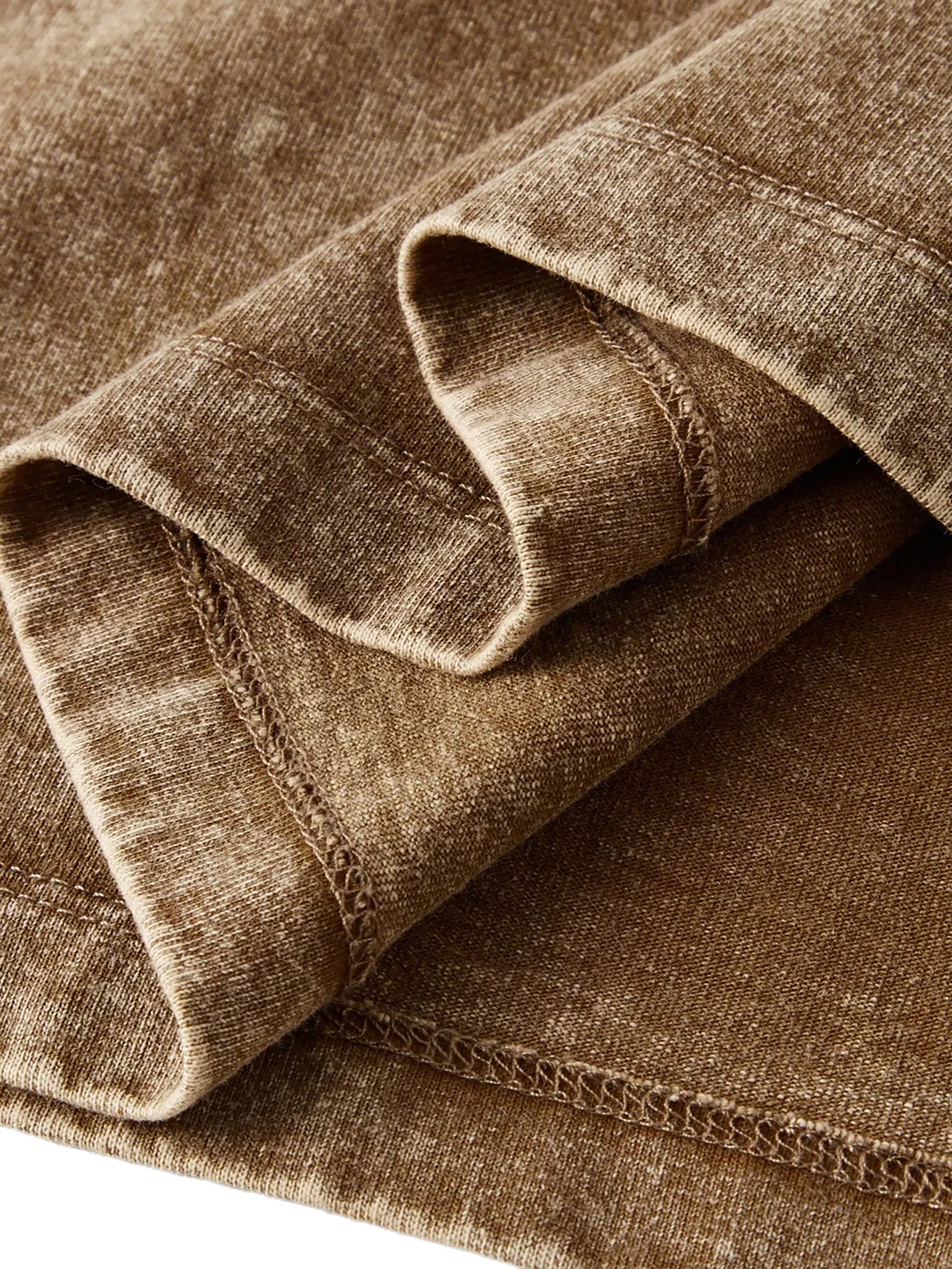 Close-up of snow washed brown kids t-shirt fabric showing detailed stitching and texture