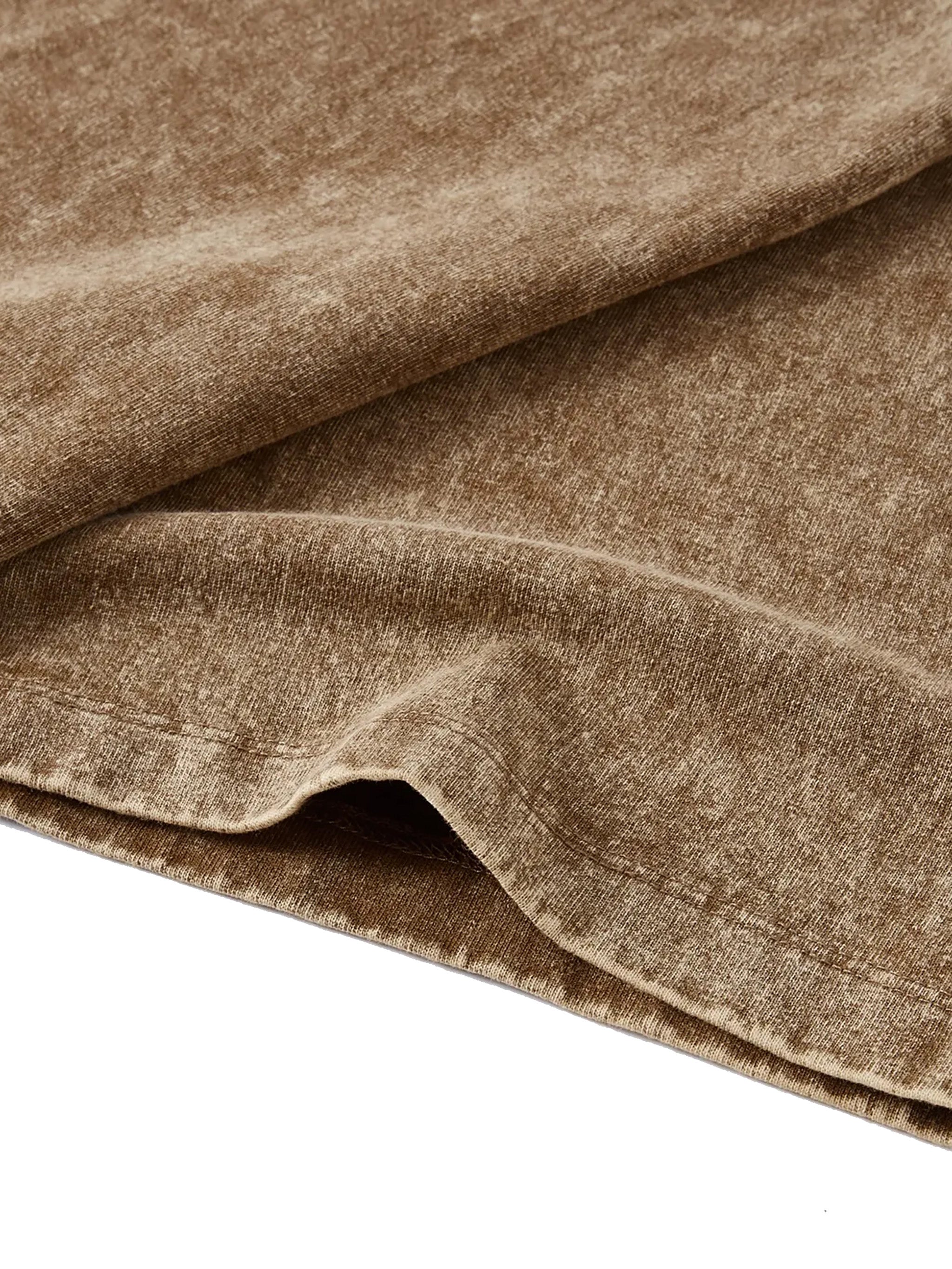 Close-up of brown snow washed kids' t-shirt hem showing textured heavyweight fabric