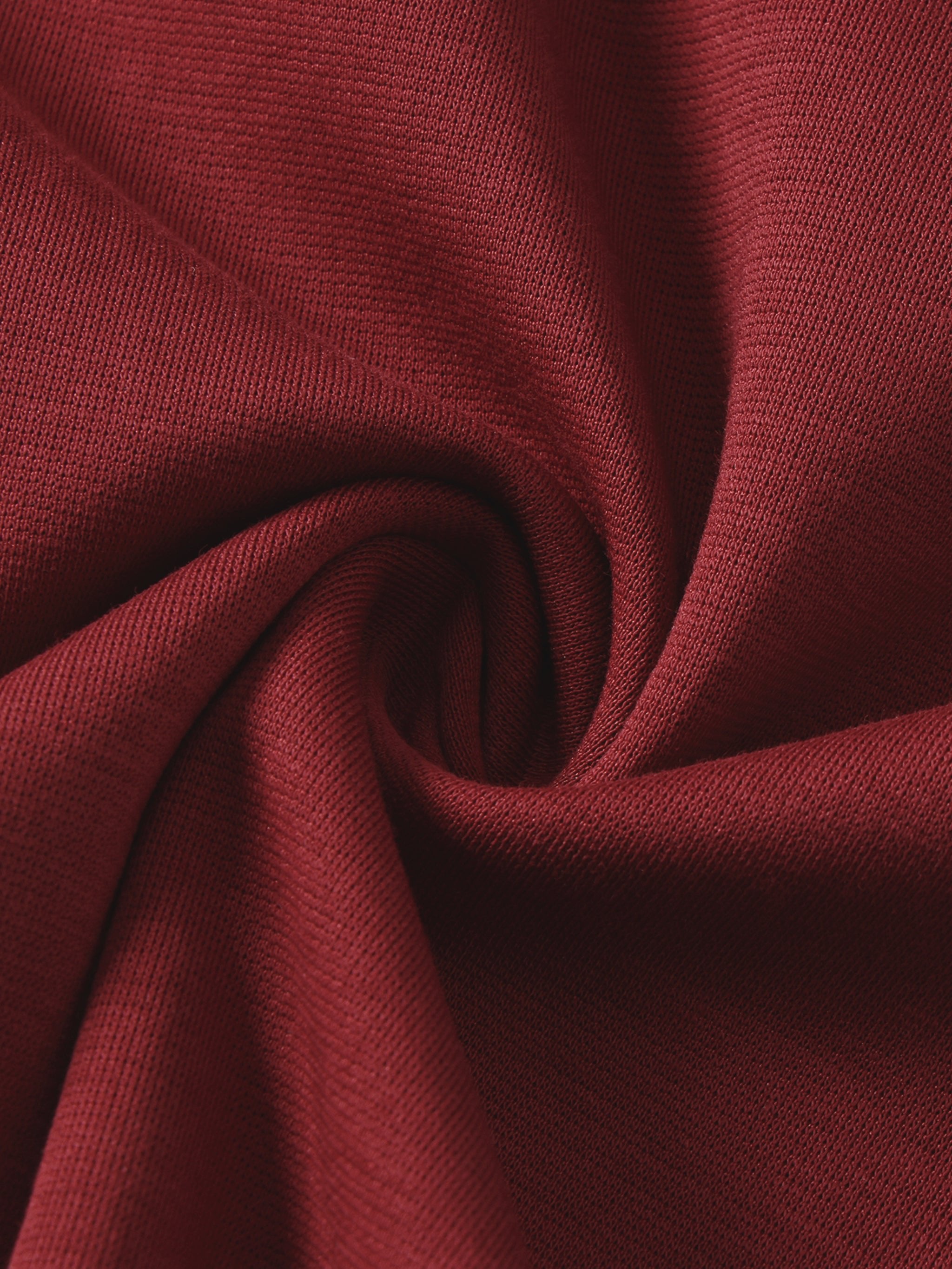 Close-up of soft, heavyweight maroon knit fabric, showing detailed texture and weave pattern.