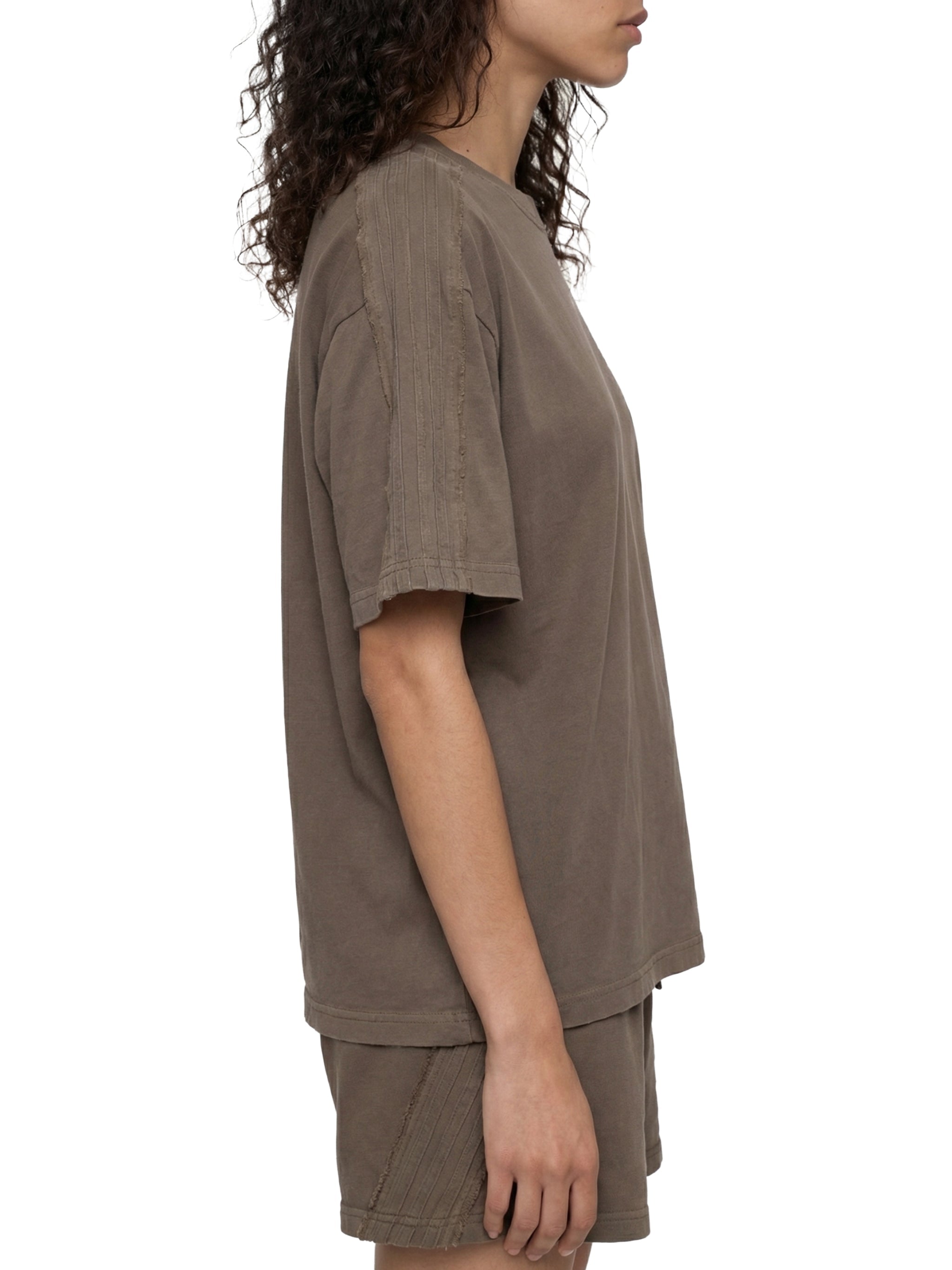 Side view of a model wearing a unisex vintage wash boxy t-shirt and matching shorts in taupe.