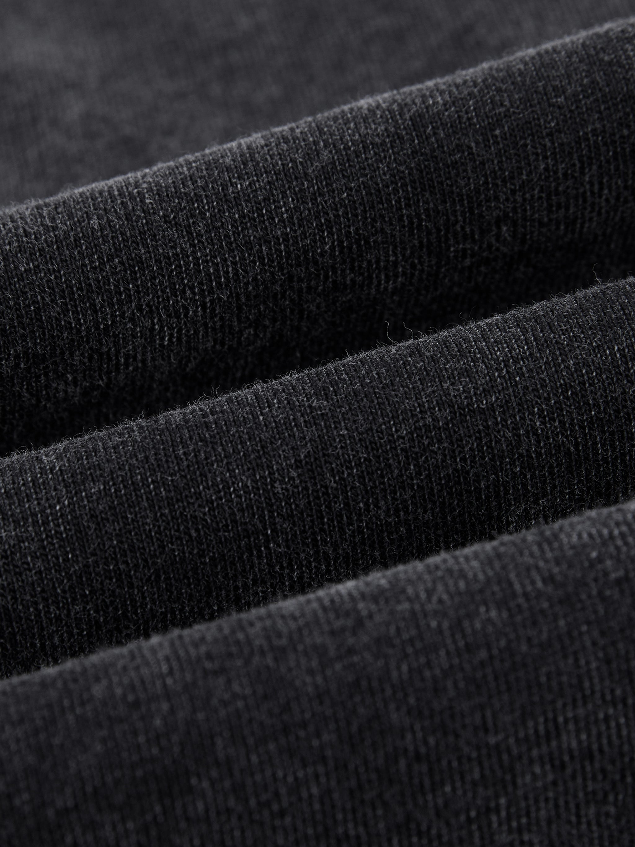 Close-up of soft black heavyweight cotton fabric with vintage wash texture
