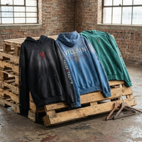 Three heavyweight sunfade oversized hoodies on wooden pallets, featuring bold graphic text.