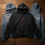 Three heavyweight sunfade oversized hoodies with graphic text and embroidery on wooden floor.