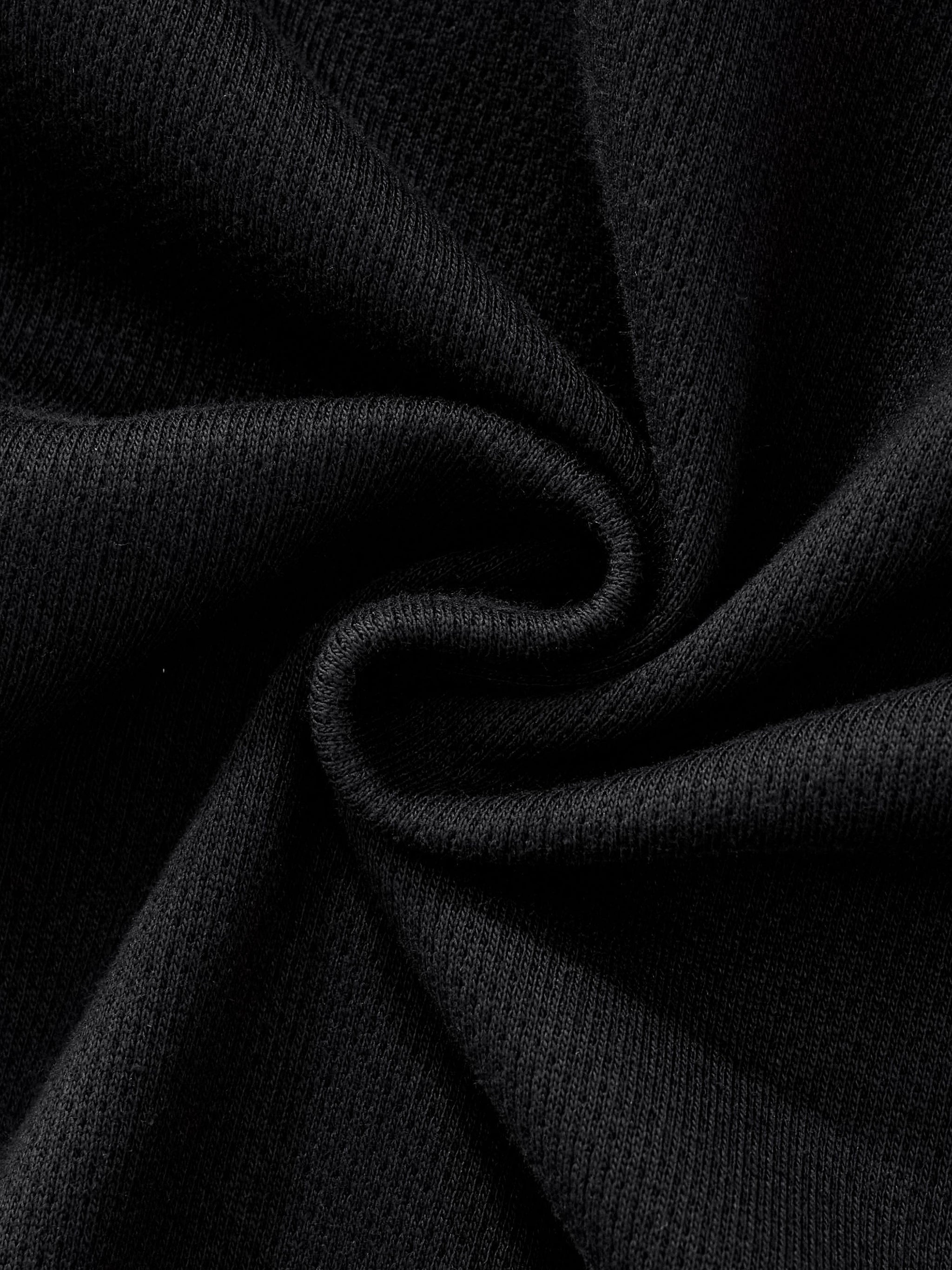 Close-up of heavyweight black fleece streetwear fabric texture, twisted for detail