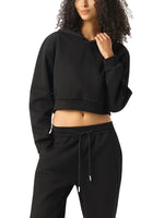 Woman wearing black cropped hoodie and joggers, modern streetwear style