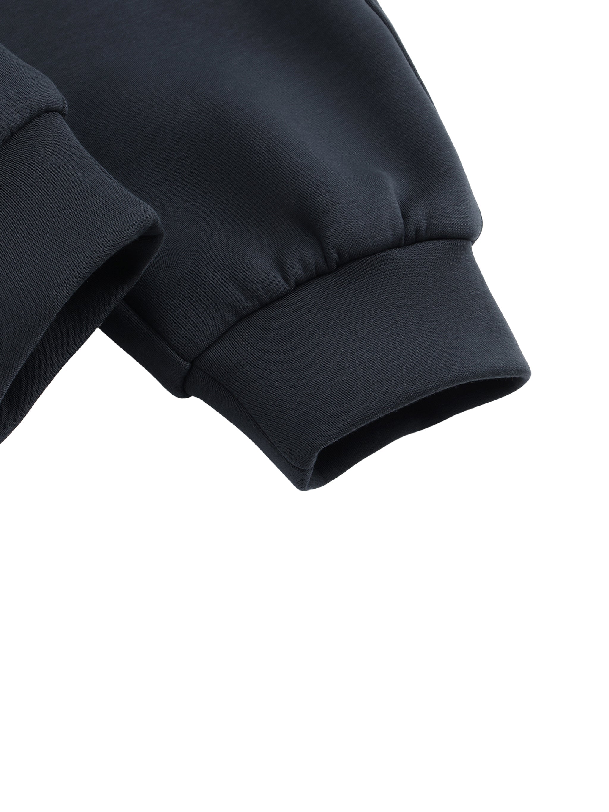 Close-up of black jogger sweatpants cuffs with ribbed hem on white background.