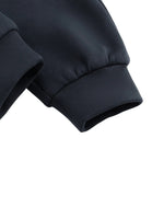 Close-up of black jogger sweatpants cuffs with ribbed hem on white background.
