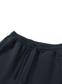 Black heavyweight drawstring sweatpants with elastic waistband and side pockets on white background