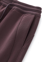 Close-up of brown drawstring straight-leg sweatpants with ribbed waistband