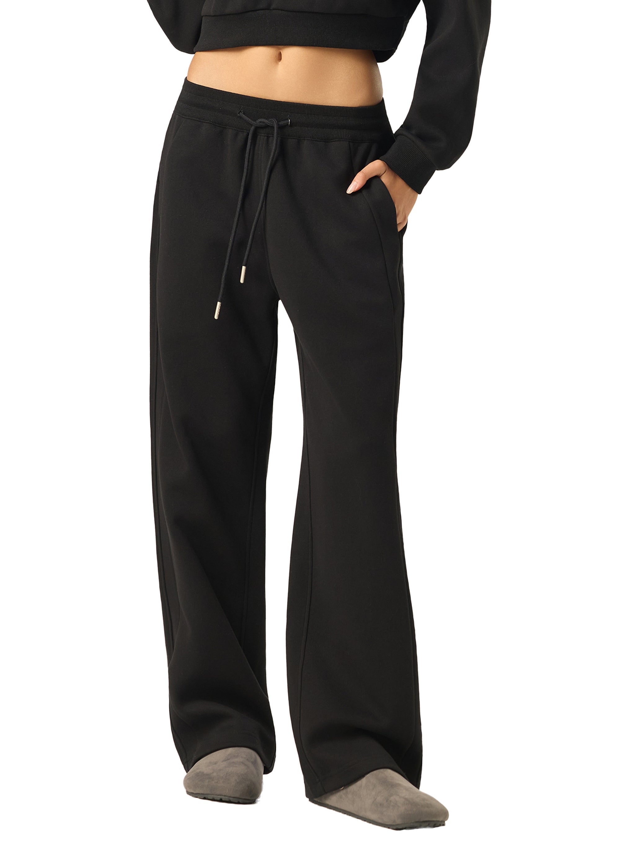 Black straight-leg sweatpants with drawstring waist, modeled with hands in pockets