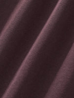 Close-up of heavyweight brown sweatpants fabric with visible texture and soft folds