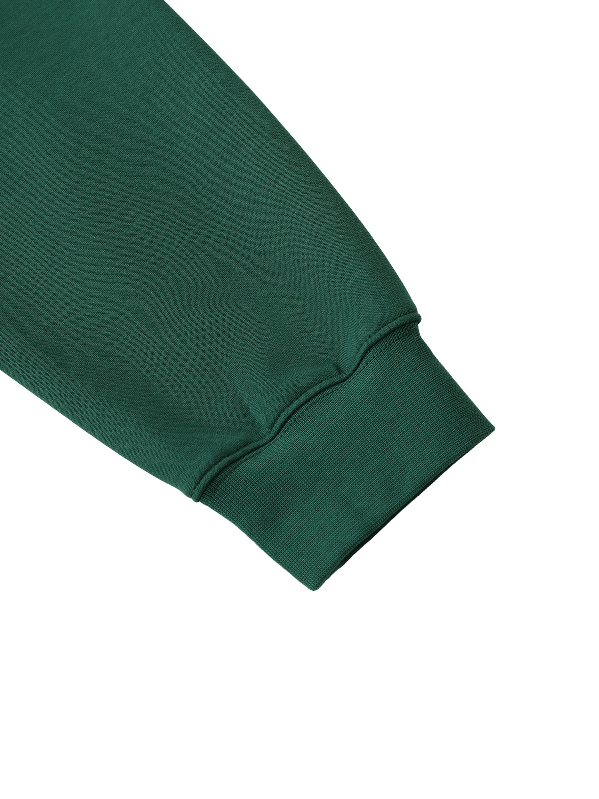 Close-up of green heavyweight crewneck sweatshirt sleeve and ribbed cuff on white background.