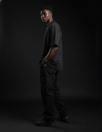 Man wearing heavyweight black knitted round neck t-shirt and cargo pants in studio