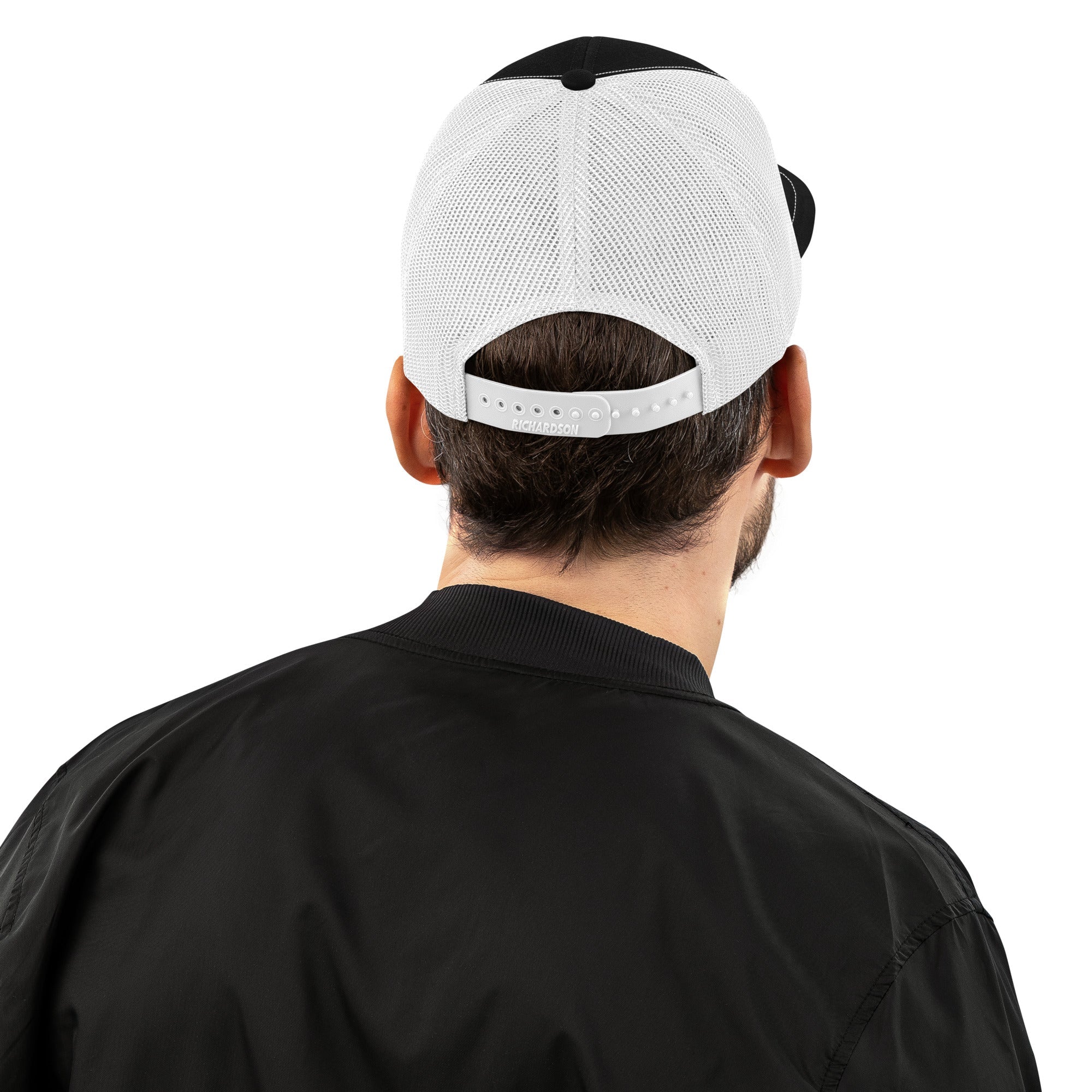 Man wearing black and white mesh trucker cap, adjustable snapback, back view