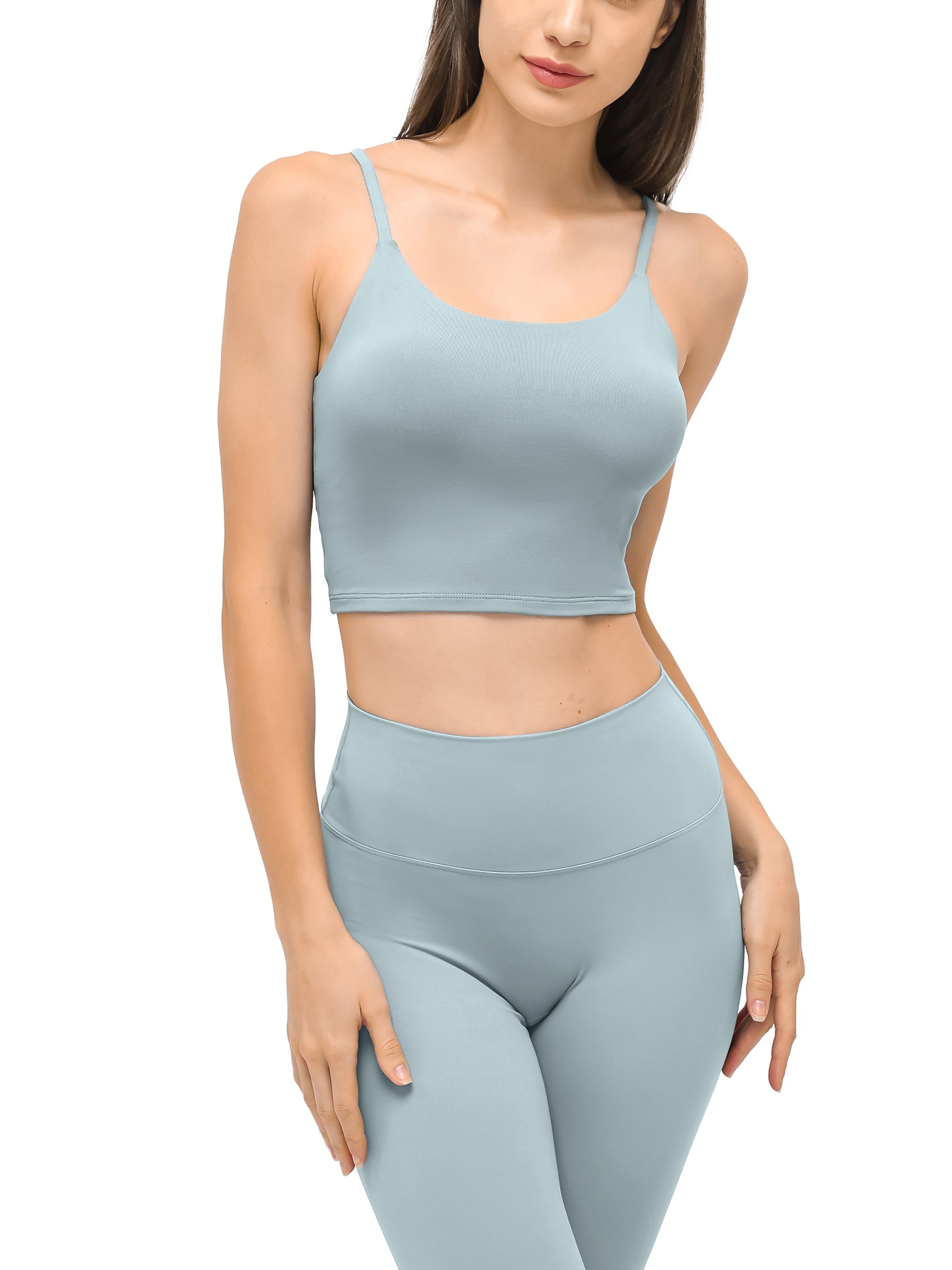 Woman wearing light blue spaghetti strap yoga sports bra and matching high-waisted leggings