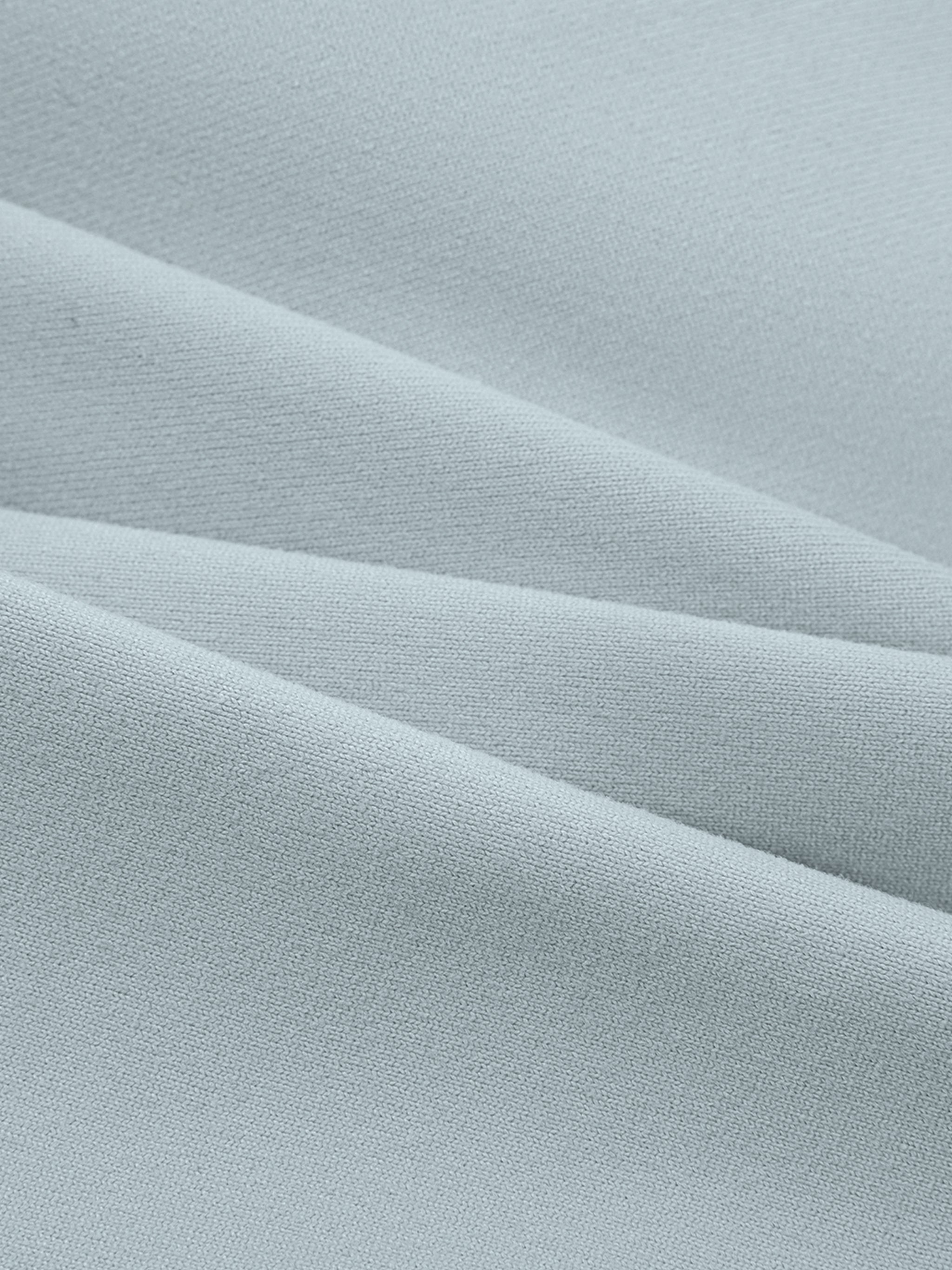 Close-up of light gray yoga sports bra fabric with soft, smooth texture and stretch folds