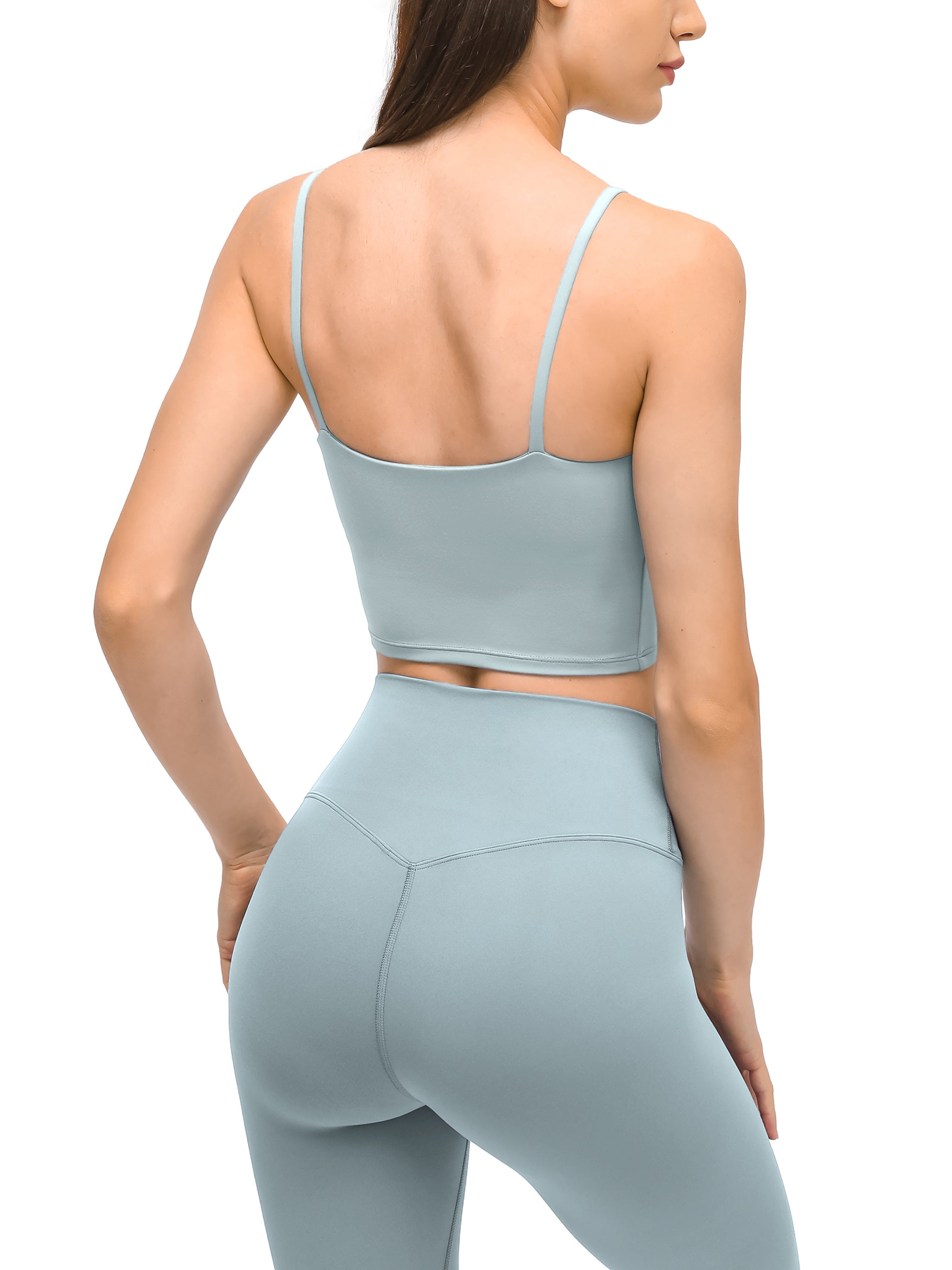 Back view of woman wearing light blue spaghetti strap yoga sports bra and matching leggings