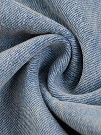 Close-up of heavyweight light blue denim fabric with a soft, textured weave.
