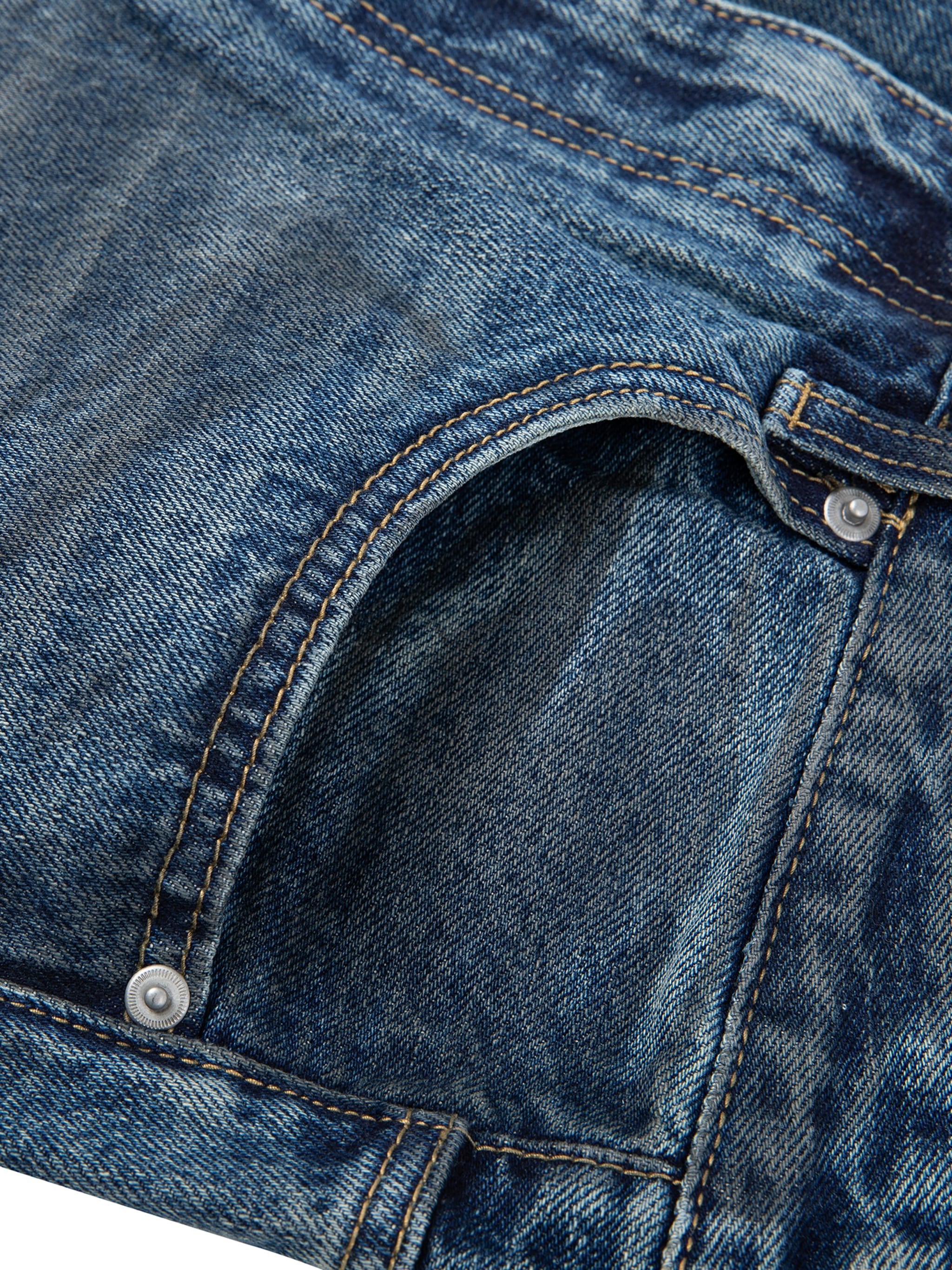 Close-up of vintage wash baggy denim jeans front pocket with contrast stitching
