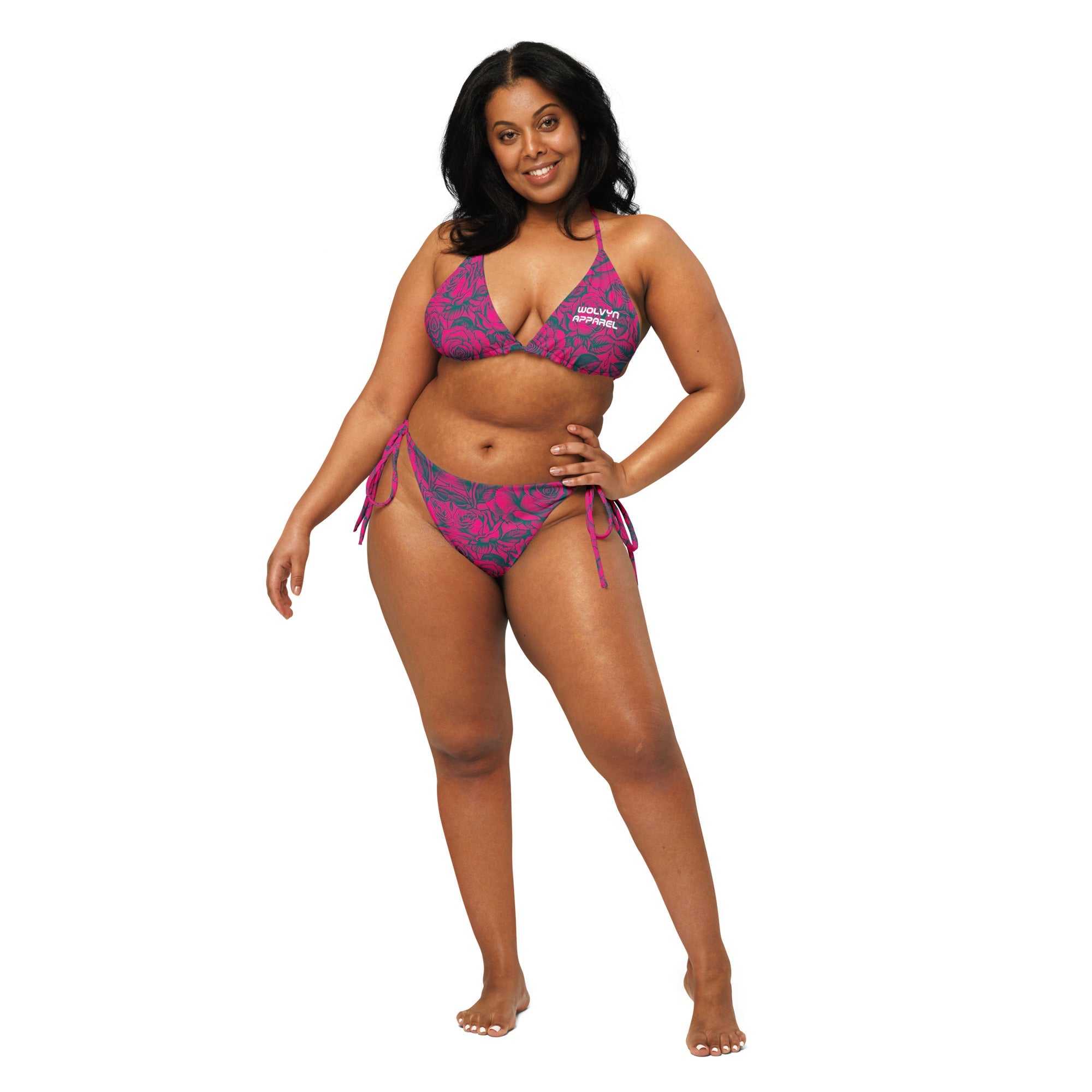 Woman wearing a pink floral string bikini with side tie bottoms against white background