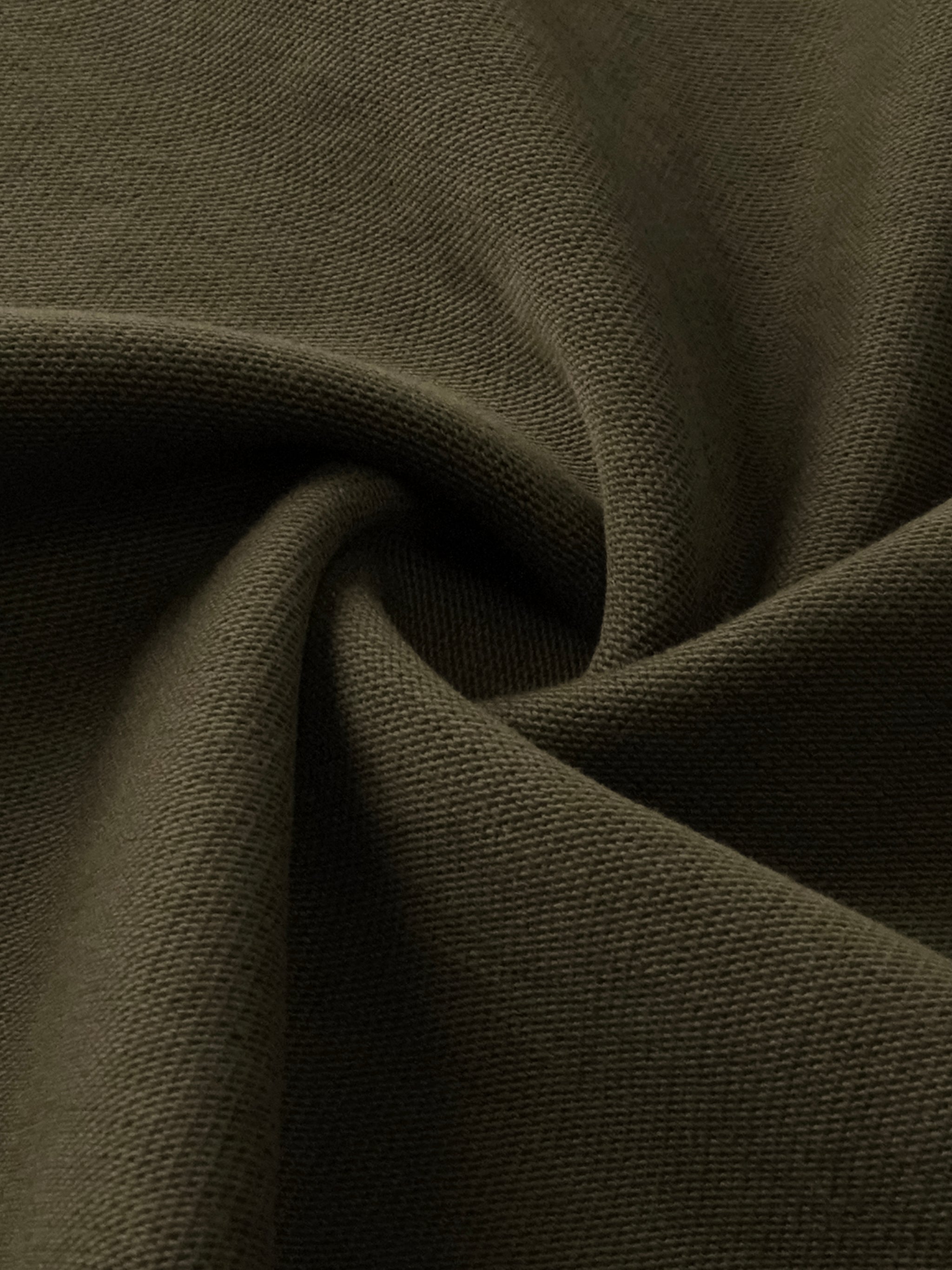 Close-up of heavyweight sun-faded olive green distressed boxy t-shirt fabric texture