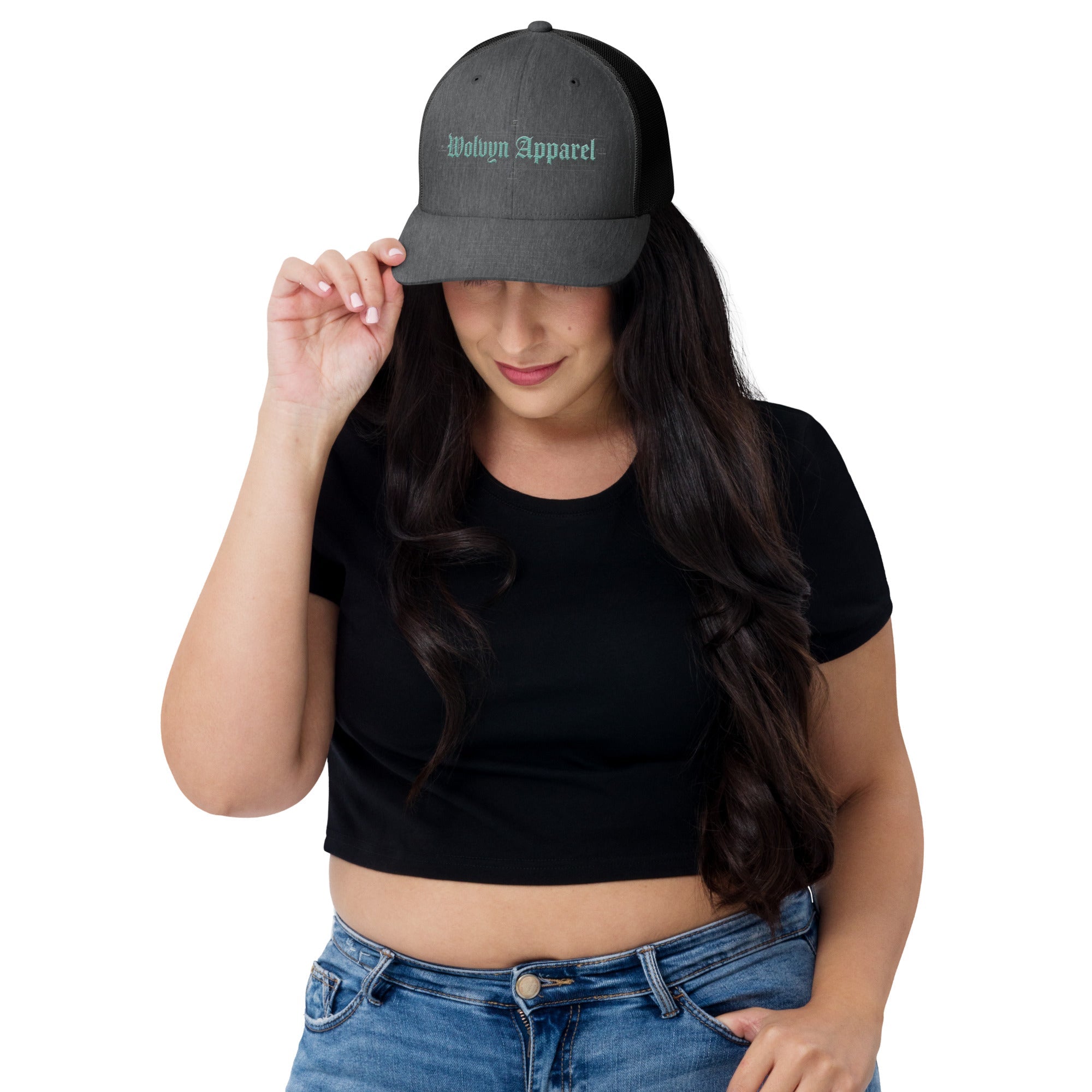 Woman wearing a black mid-profile trucker cap with embroidered Wolvyn Apparel text