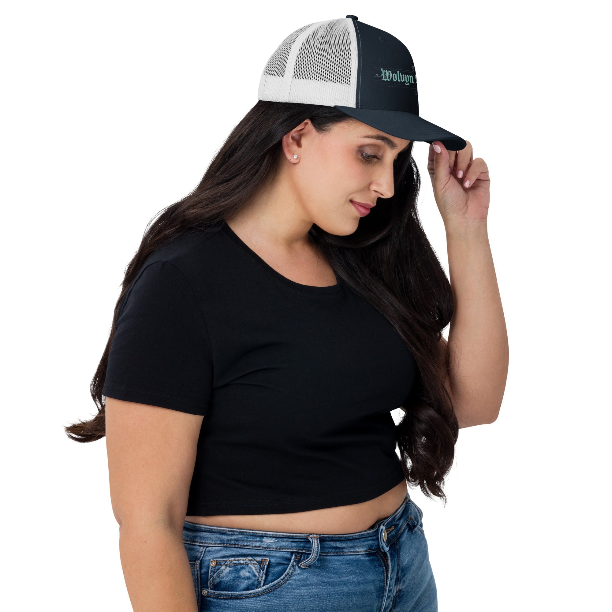Woman wearing a white mesh-back embroidered trucker hat and black crop top