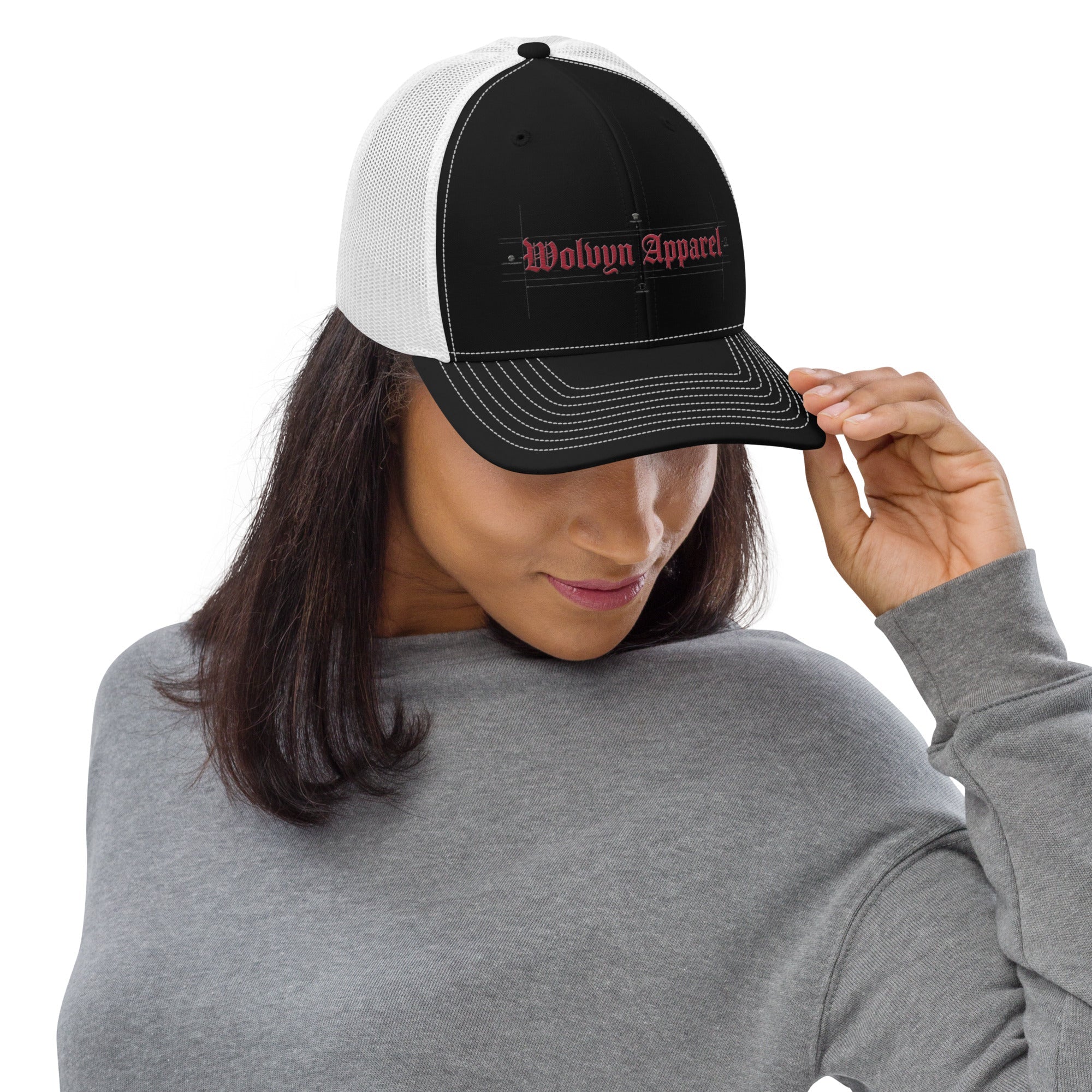 Woman wearing black and white embroidered trucker cap with mesh back and gothic text.