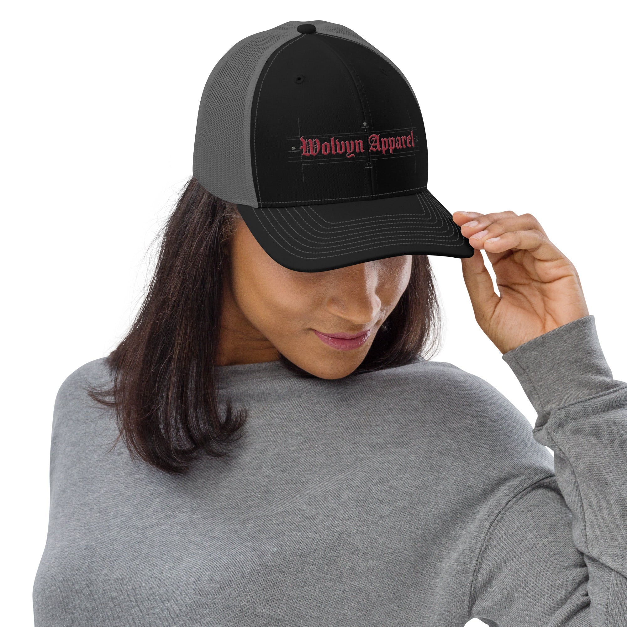 Woman wearing a black Richardson trucker cap with red embroidered Wolvyn Apparel logo
