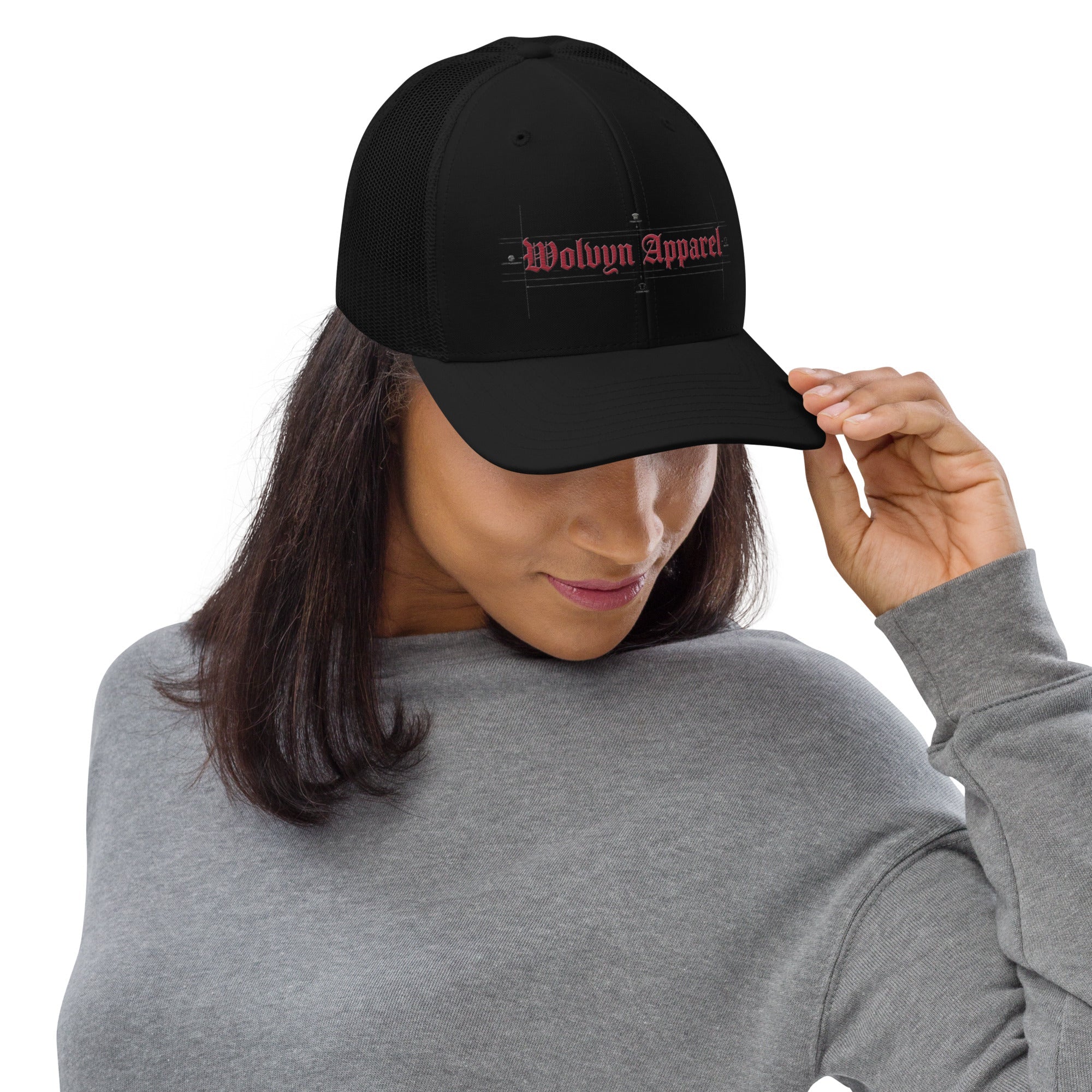 Woman wearing black embroidered trucker cap with mesh back and red text on front