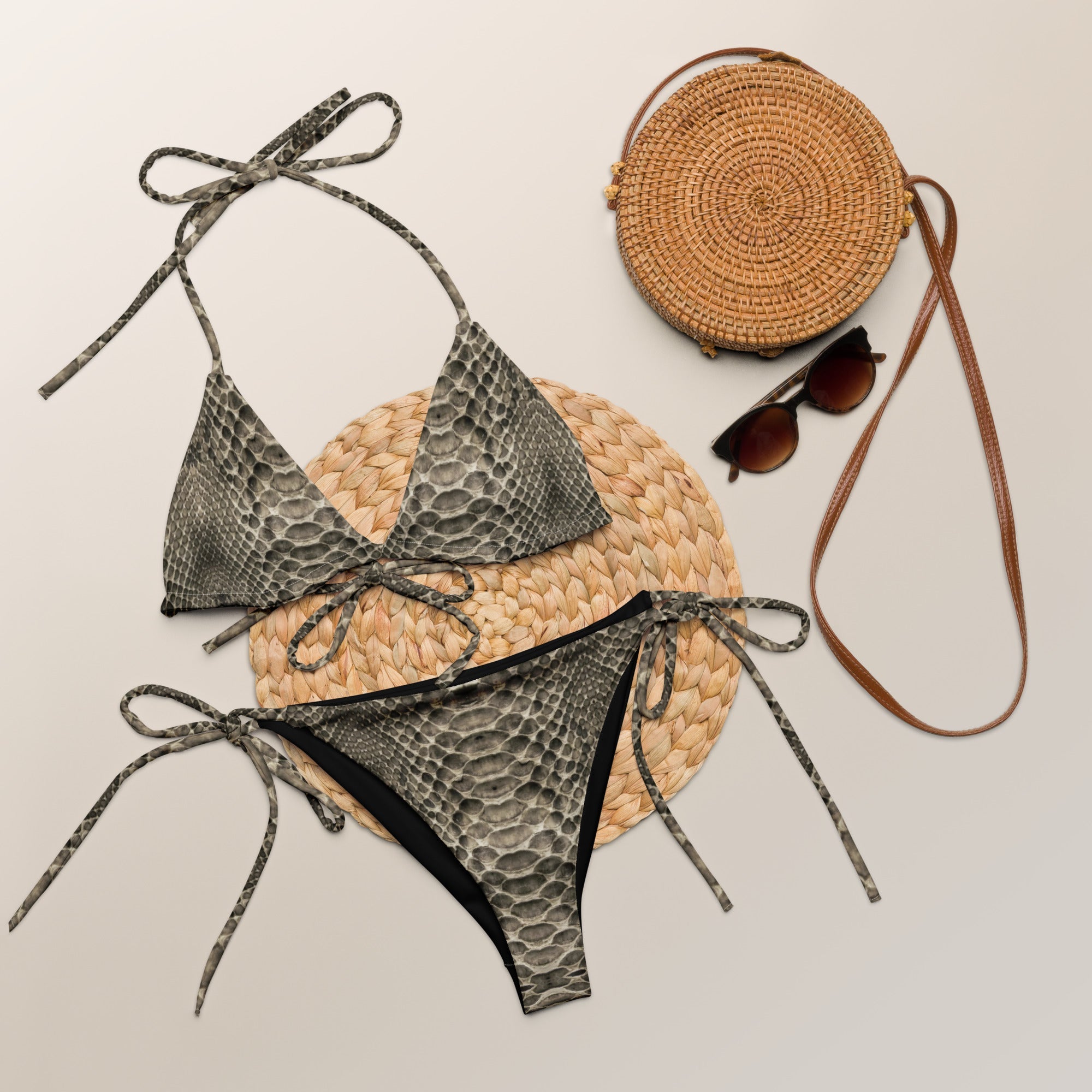 Desert snake print bikini set with tie straps, round straw bag, and sunglasses on neutral background