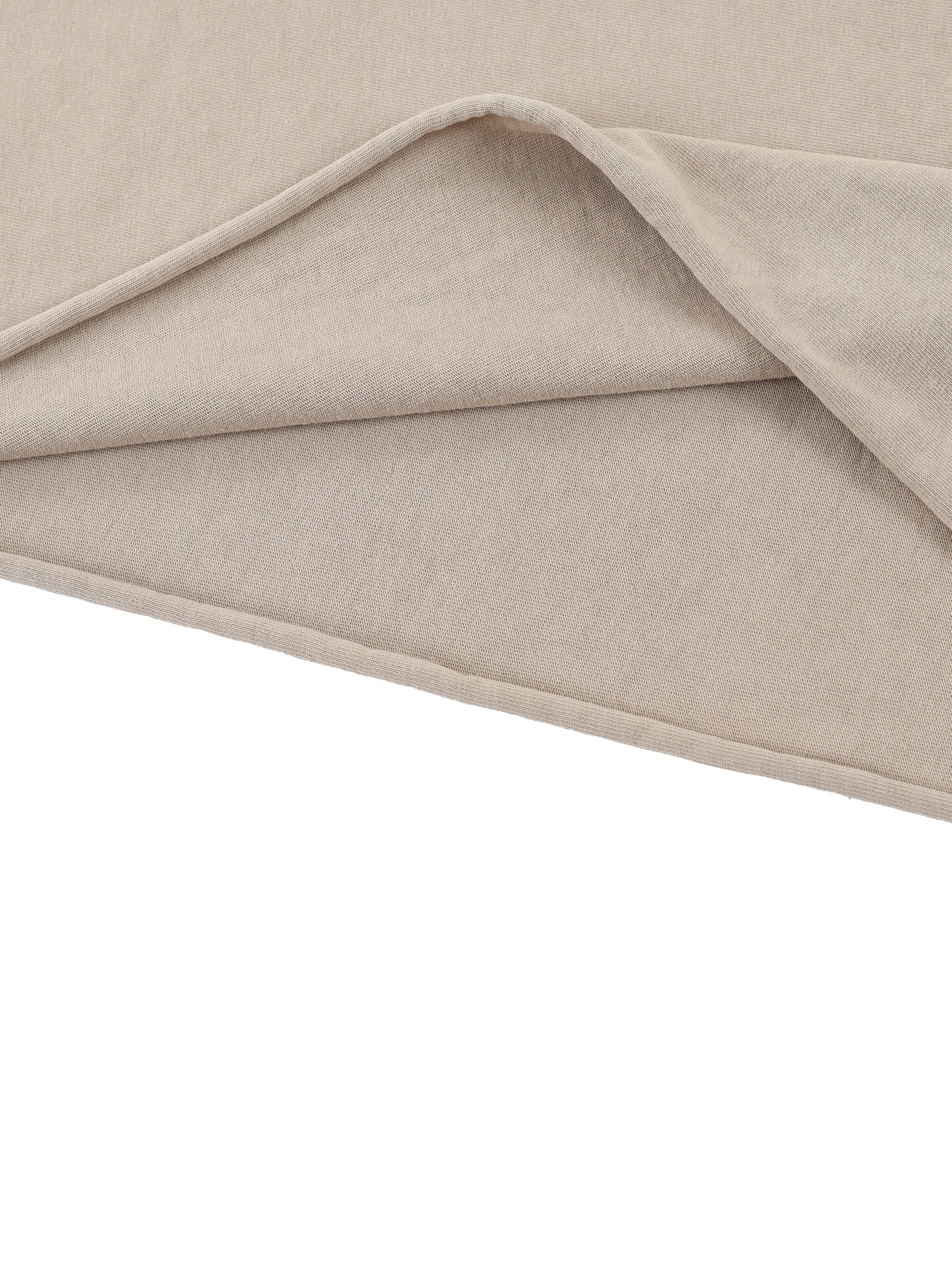 Close-up of beige heavyweight raw edge T-shirt fabric with visible texture and layers