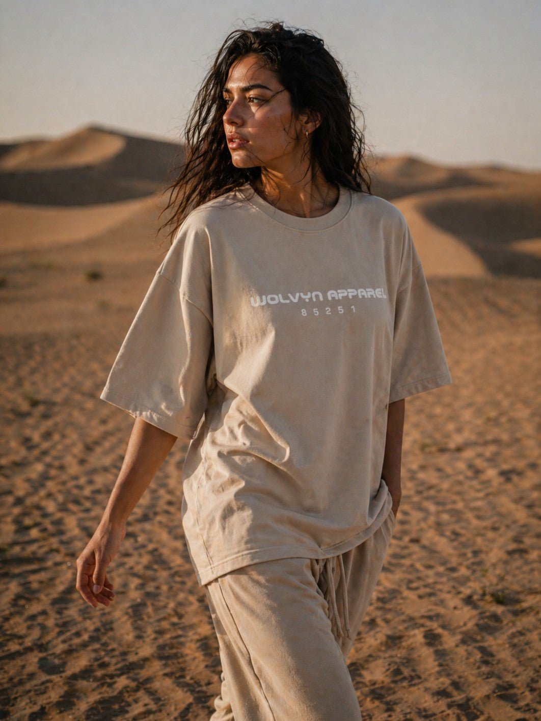 Woman wearing oversized beige heavyweight boxy t-shirt with raw edge in desert dunes