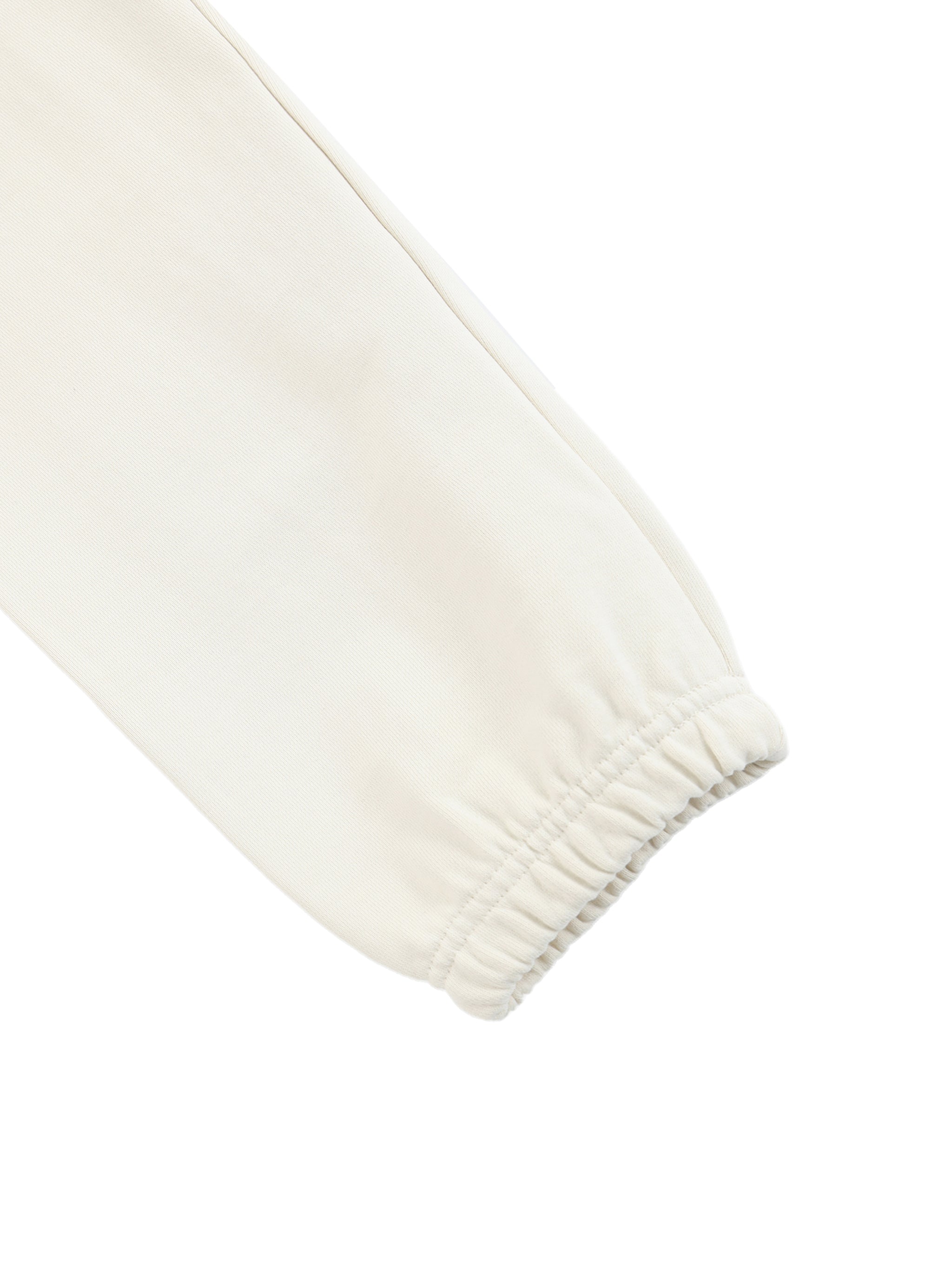 Close-up of off-white heavyweight cotton sweatpants with elastic cuff