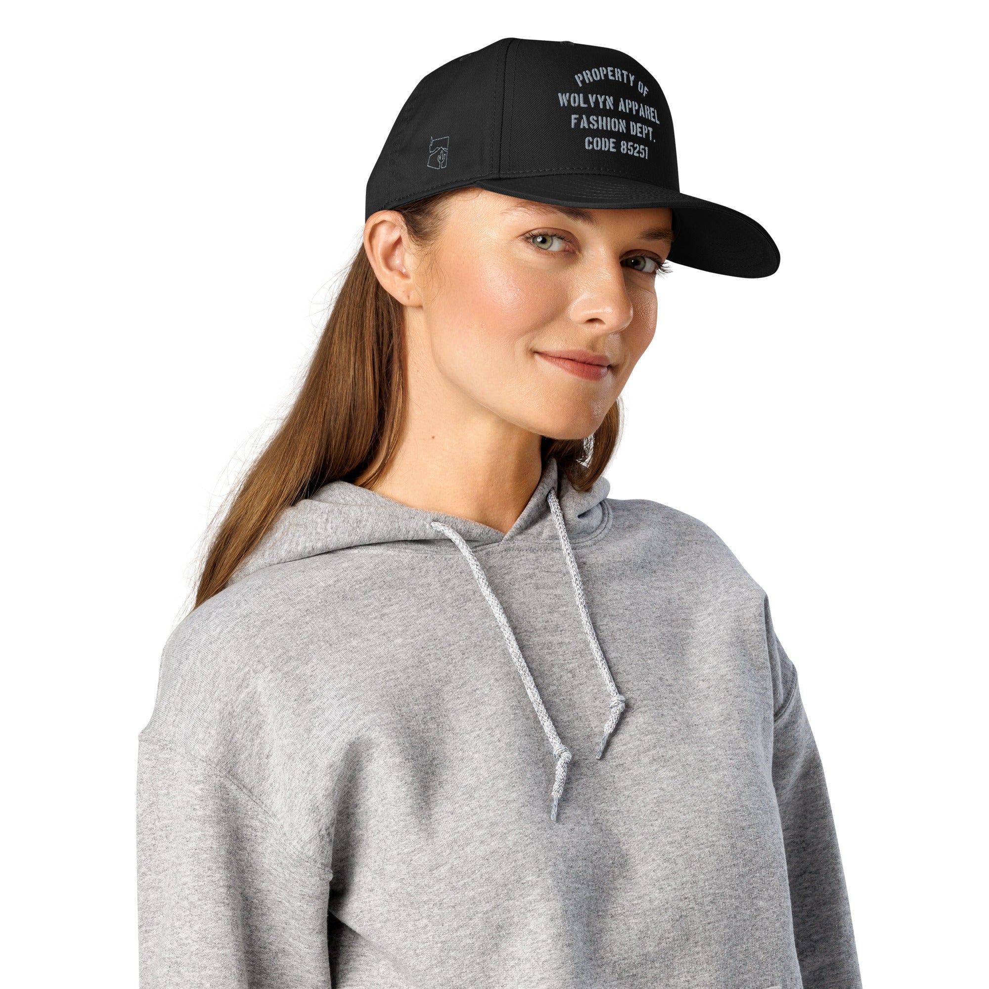 Woman in gray hoodie wearing a black 5-panel cap with white embroidered text
