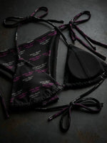 Black string bikini set with purple and white script font pattern on dark surface