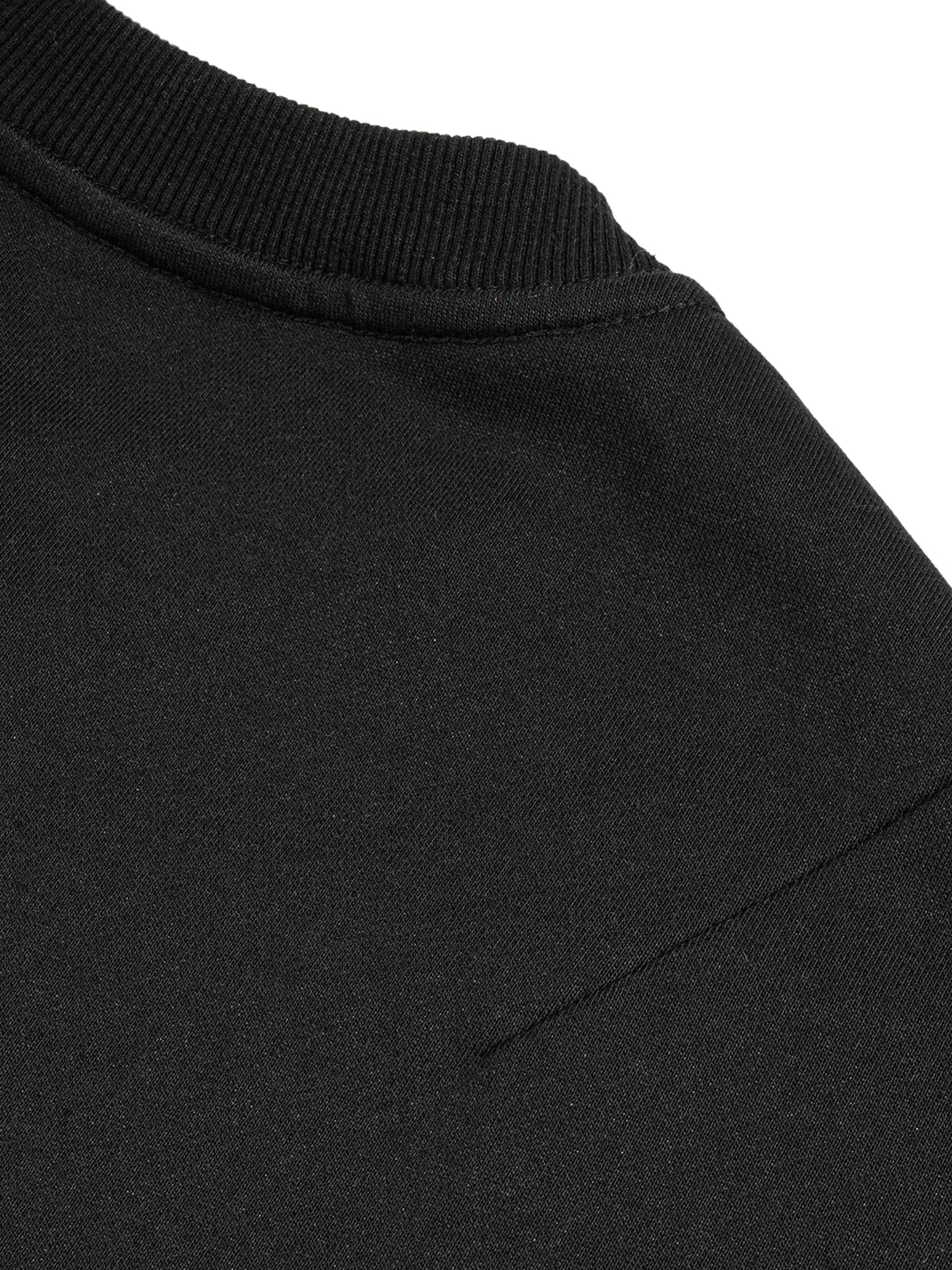 Close-up of black French terry tank top shoulder with ribbed neckline and seam detail