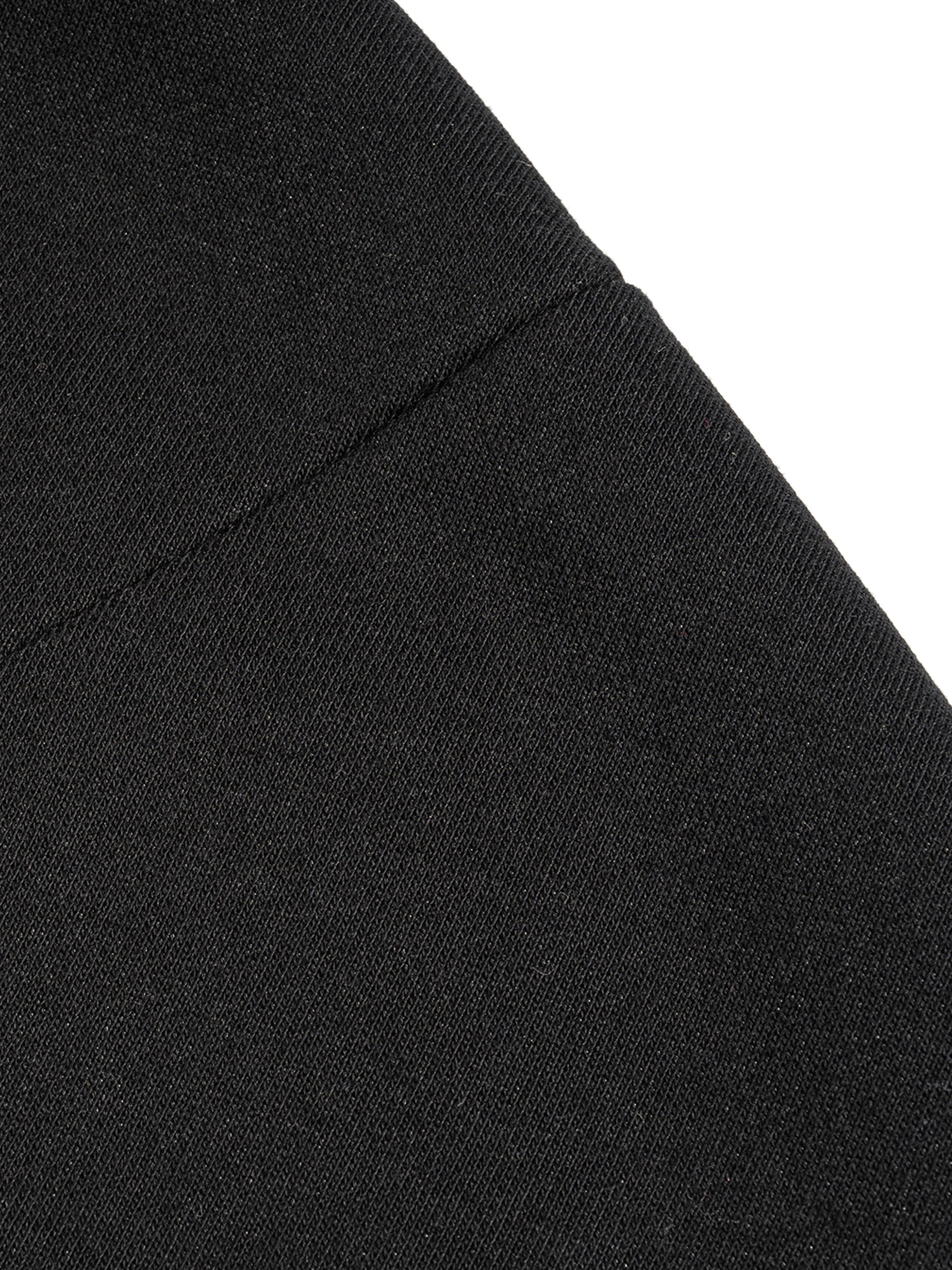 Close-up of black French terry tank top fabric showing texture and stitching detail