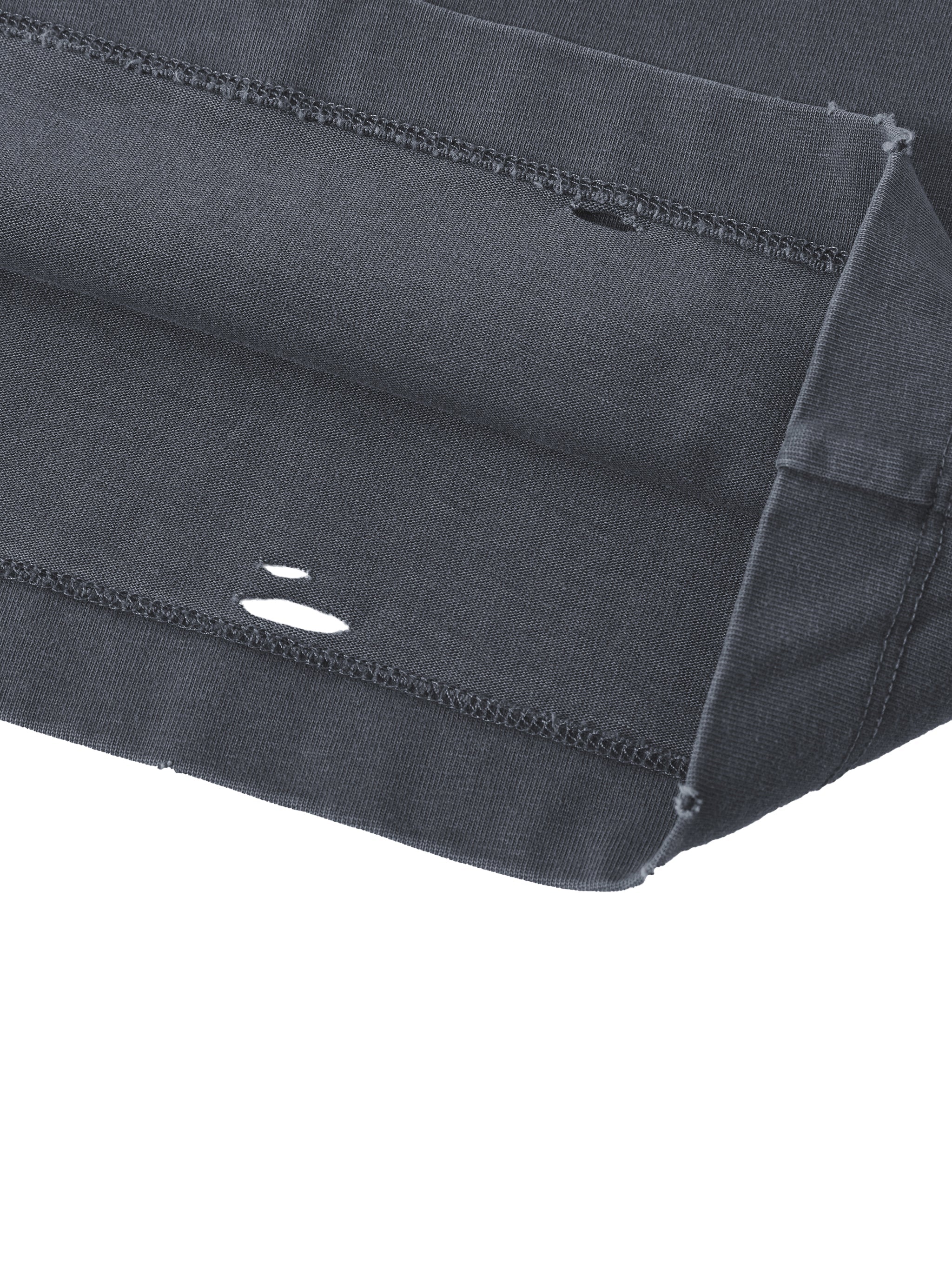 Close-up of a black distressed oversized t-shirt sleeve with washed vintage finish