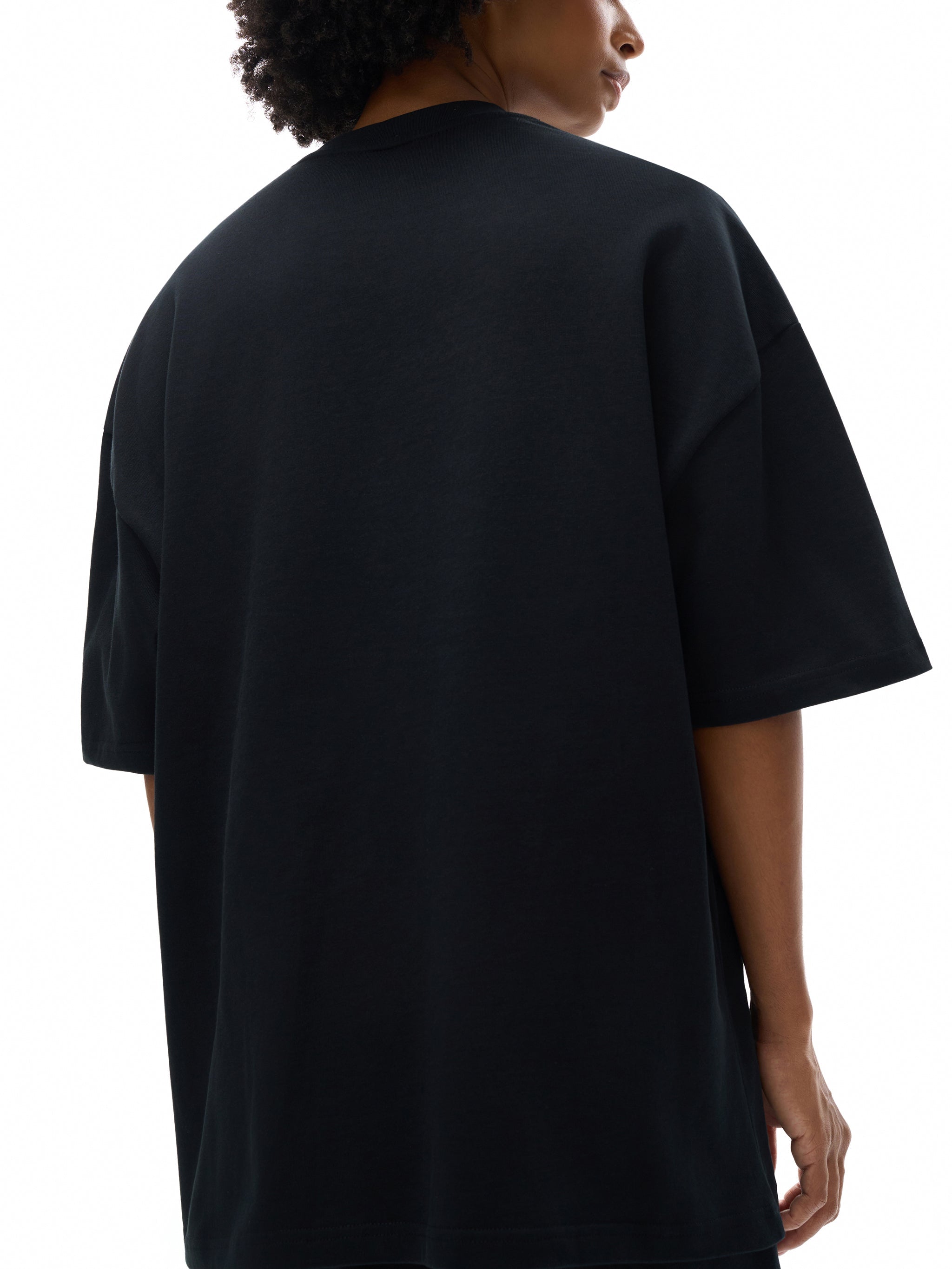 Back view of person wearing heavyweight black cotton oversized t-shirt