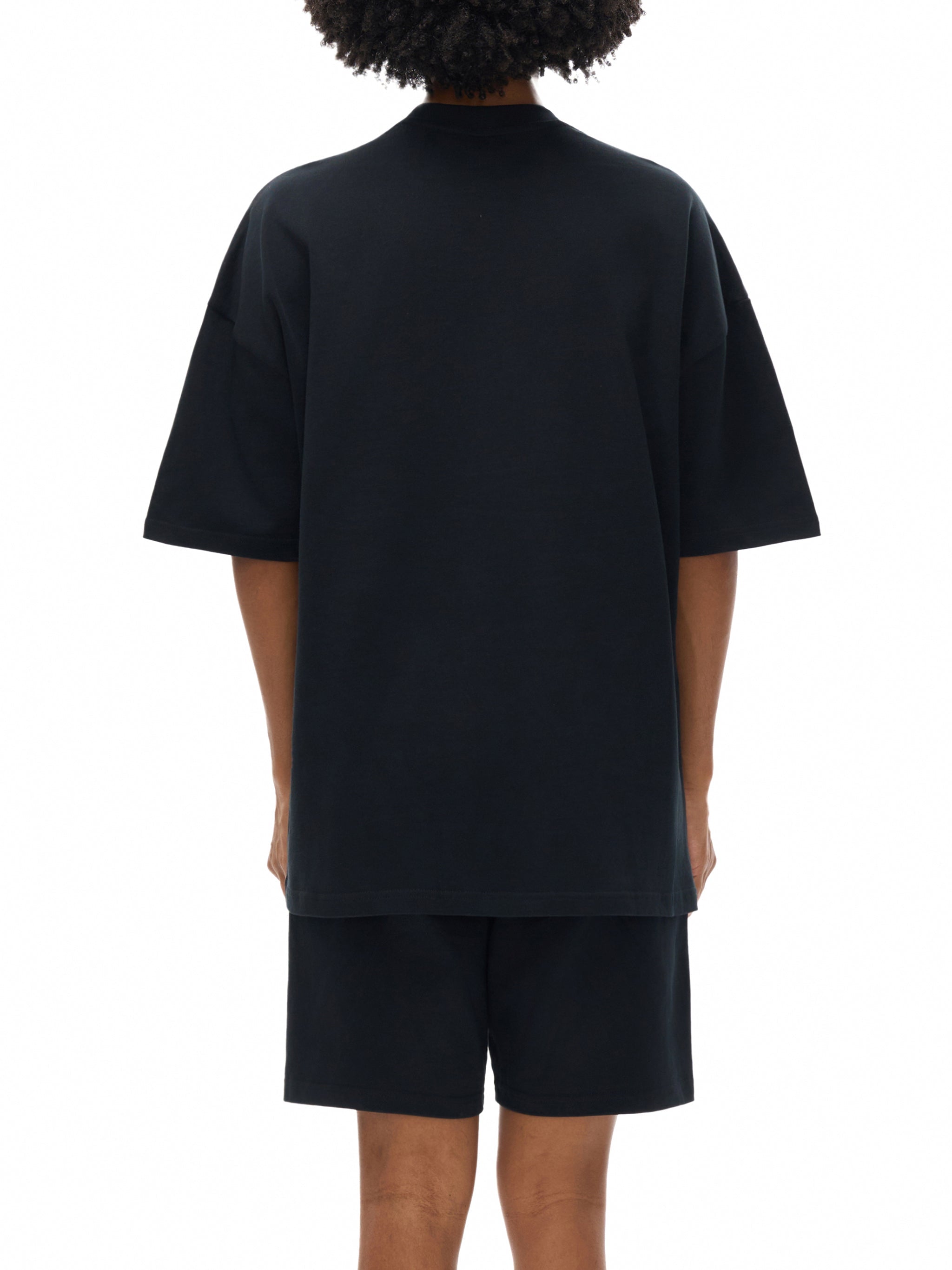 Back view of person wearing black heavyweight cotton t-shirt and matching shorts