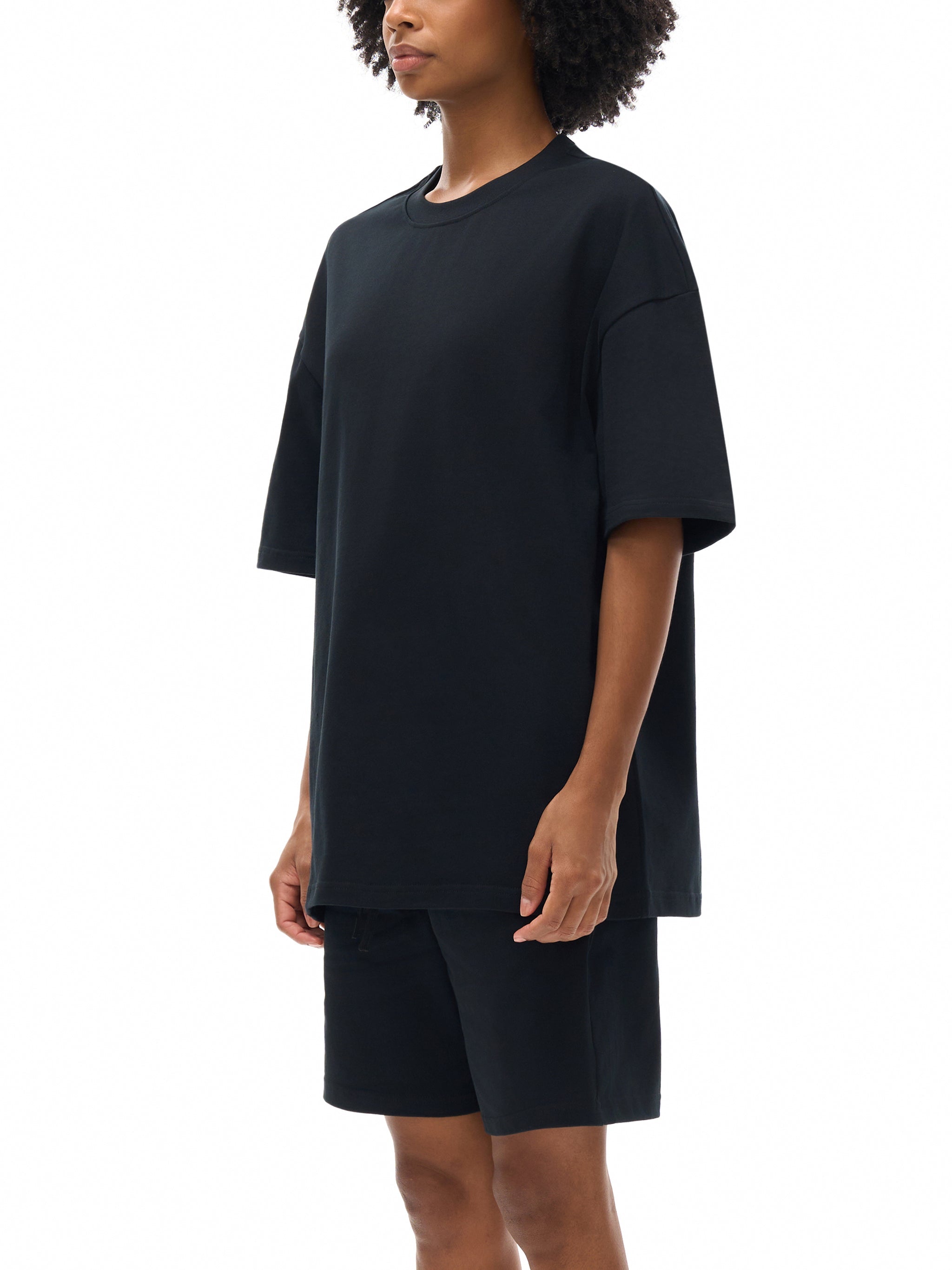 Model wearing oversized black heavyweight cotton t-shirt and matching shorts