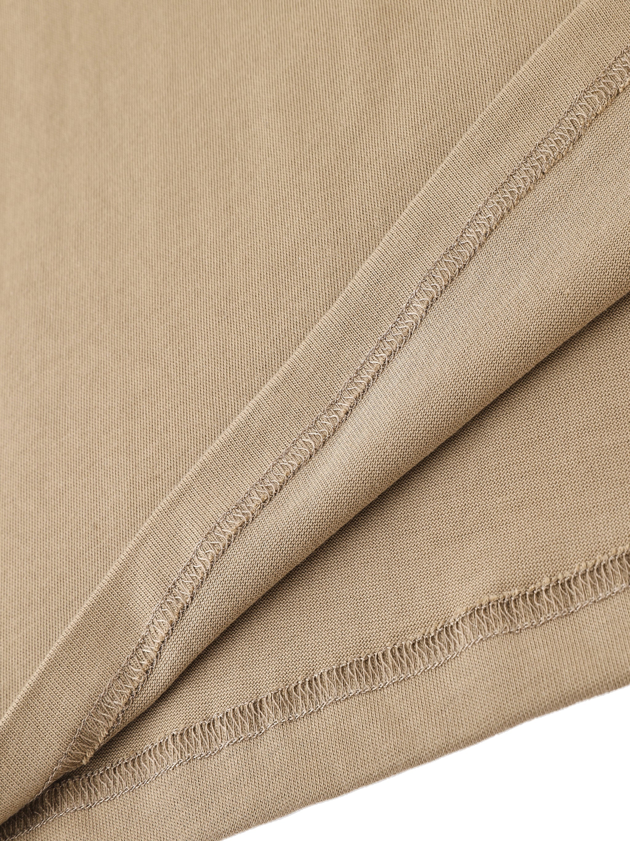Close-up of heavyweight cotton t-shirt hem in beige, showing detailed stitching