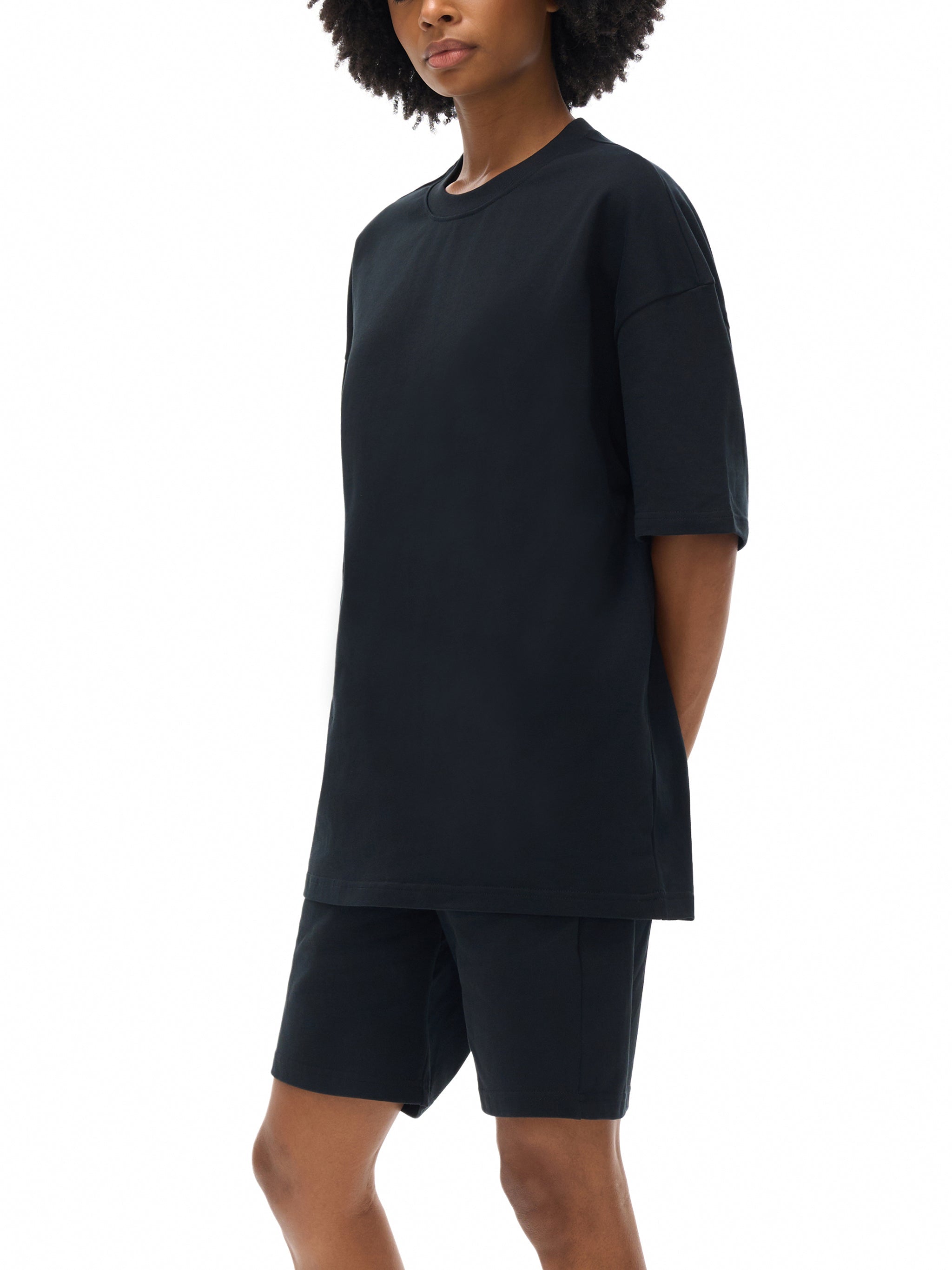 Model wearing black heavyweight cotton oversized t-shirt and shorts on white background
