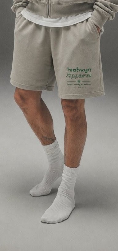 Beige heavyweight cotton shorts with front green logo print, worn with white socks.