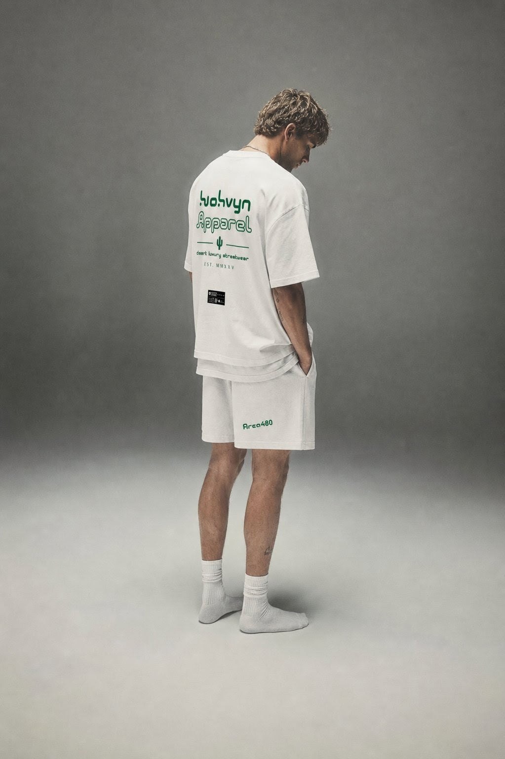 Man wearing white heavyweight cotton streetwear t-shirt and shorts with green text print