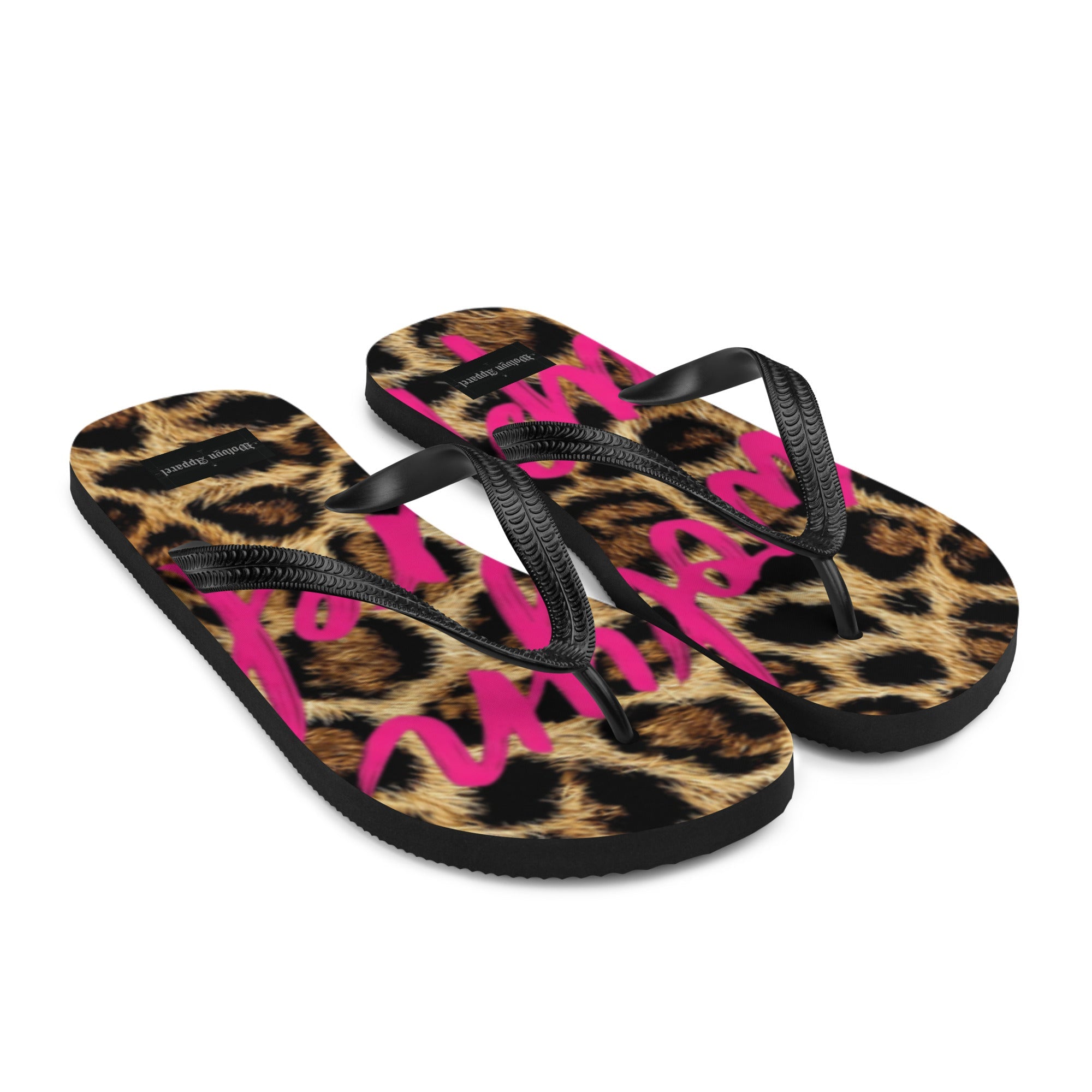 Leopard print flip flops with black straps and bold pink graphic text on the footbed