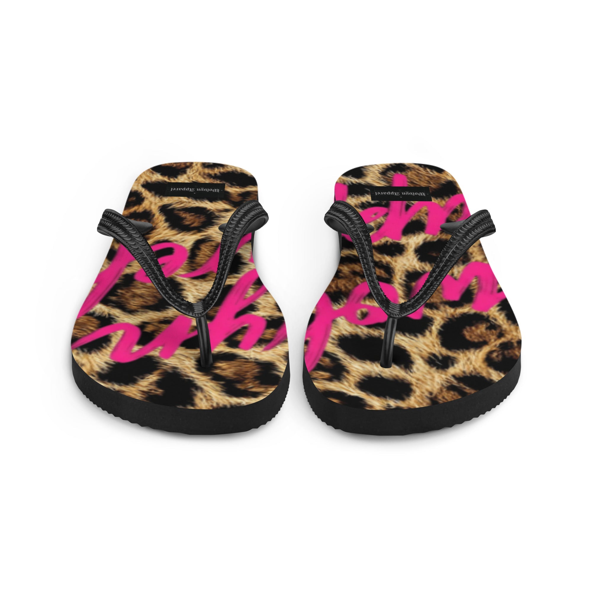 Leopard print flip flops with black straps and bold pink lettering on the footbed