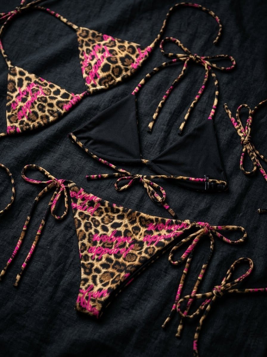 Leopard print string bikini set with pink accents and black fabric details on a dark background